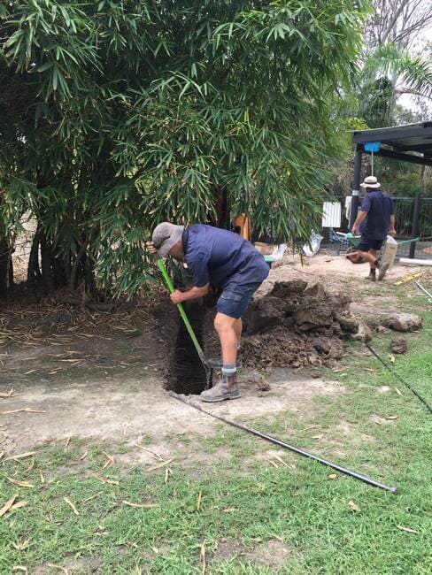 Plumber digging hole for septic tank installation