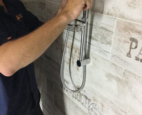 plumber repairing shower head for leaking in gladstone