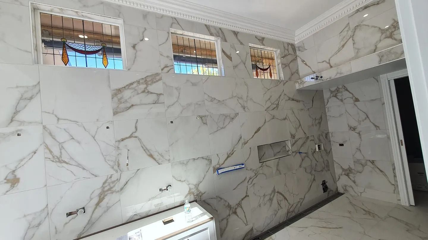 White marble tiled wall with three small windows and open doorway — David Son Tiling in Springdale Heights, NSW