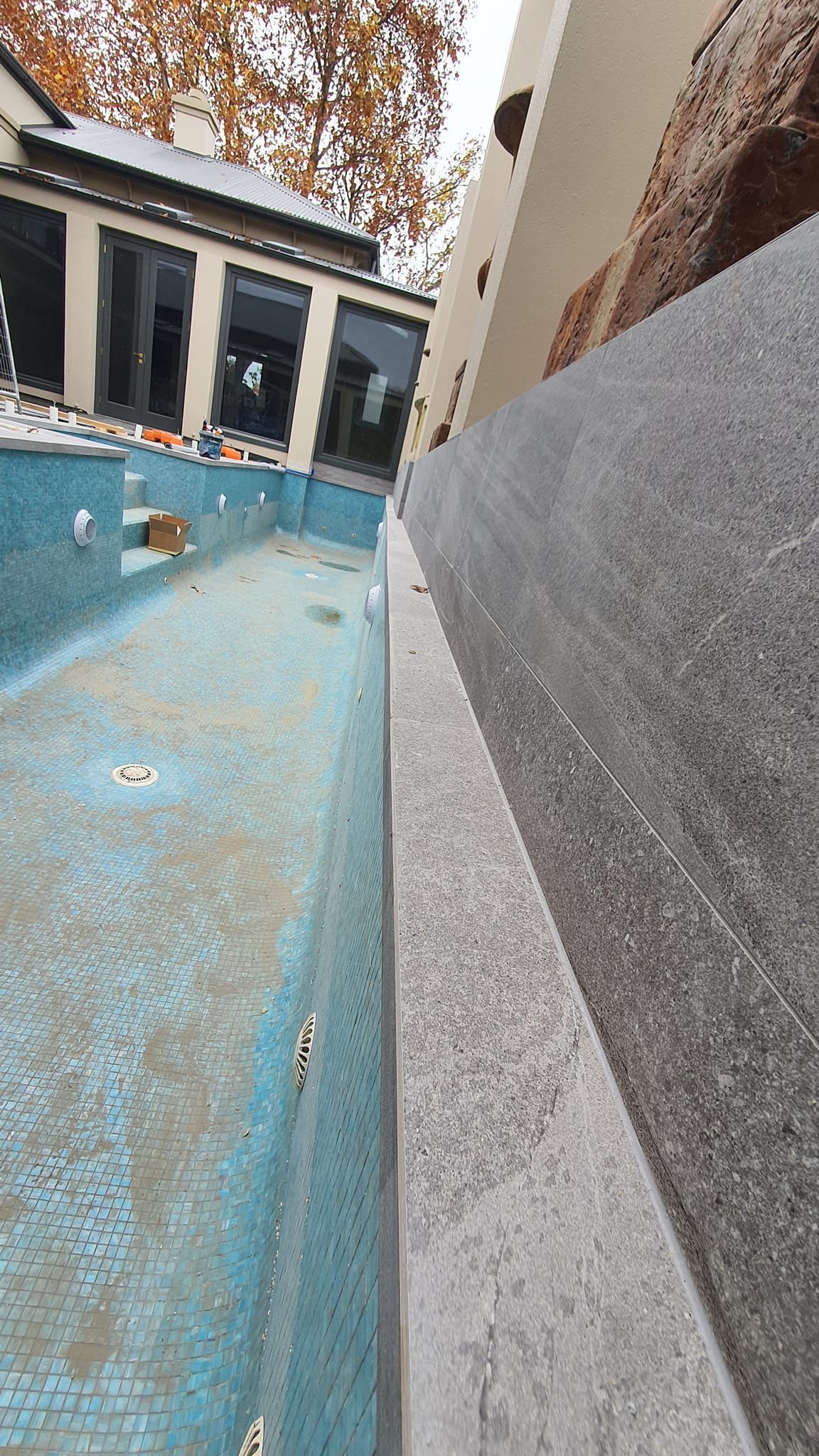 Person Applying Mortar To Floor With Trowel, Placing Tile For Installation — David Son Tiling in Springdale Heights, NSW
