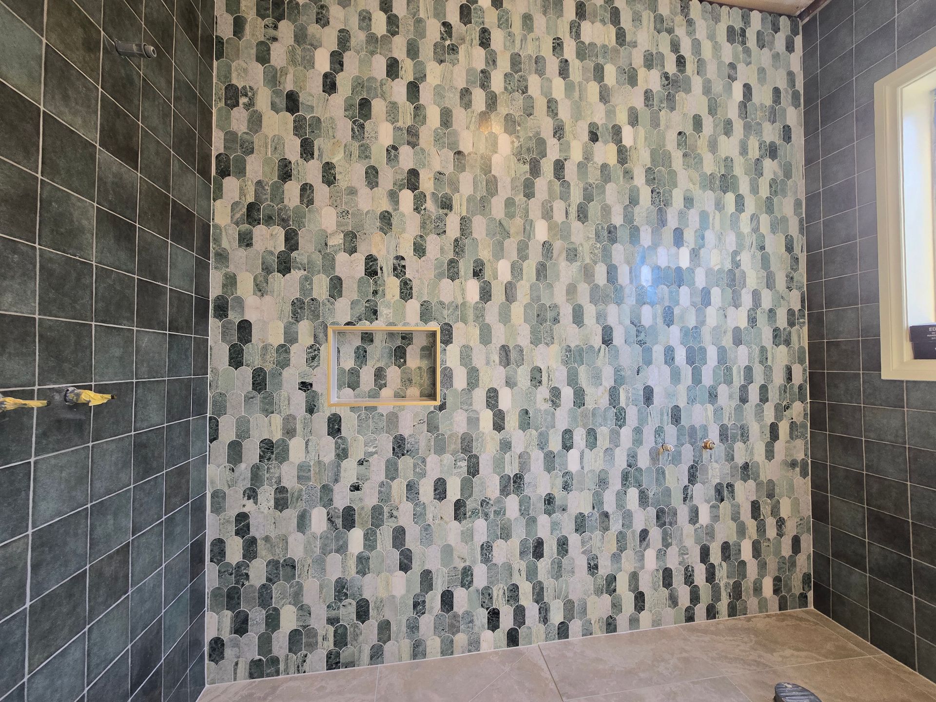 Shower with dark grey square tiles and green/grey patterned accent wall — David Son Tiling in Springdale Heights, NSW