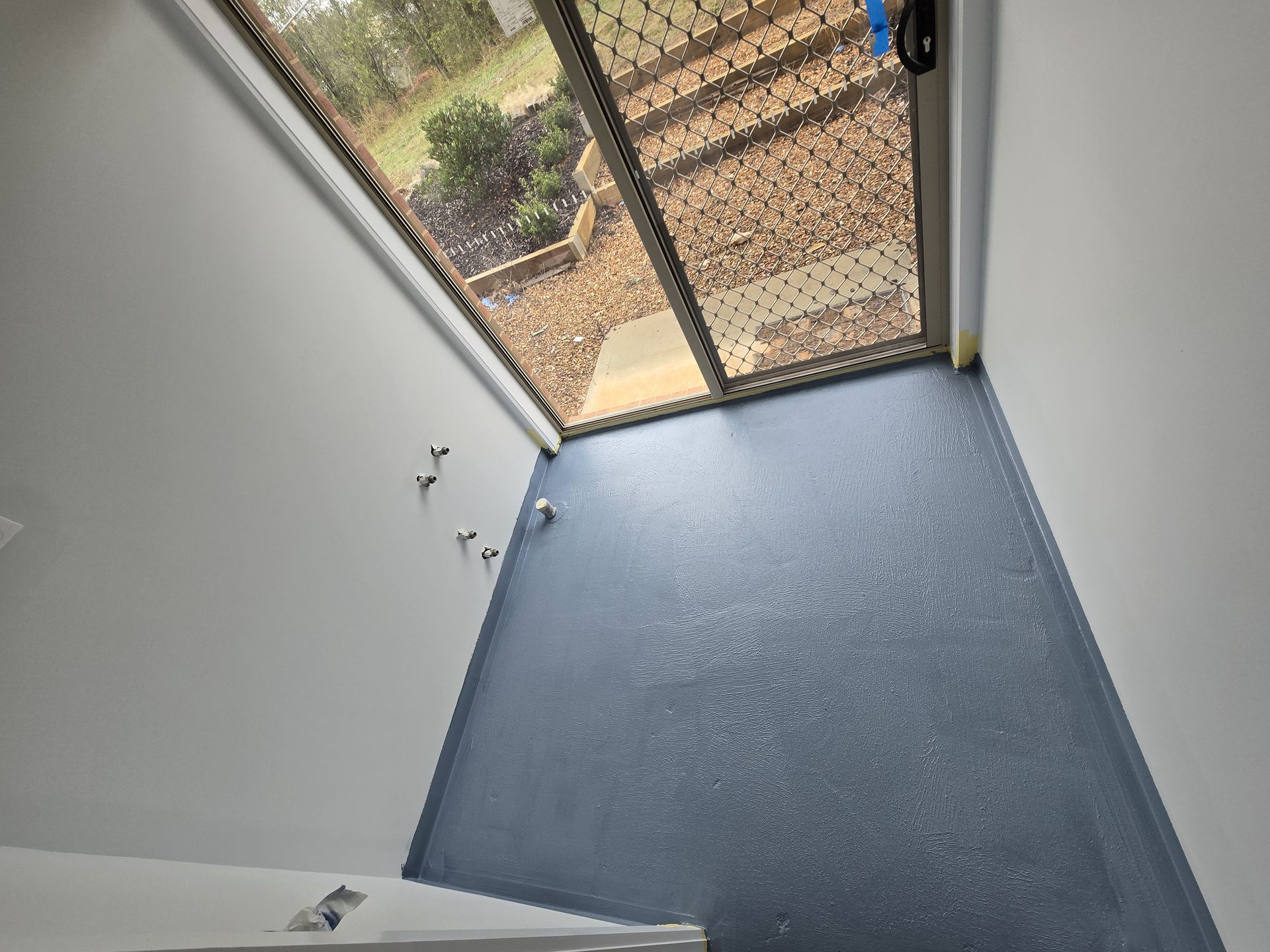 Room Under Construction With Blue Walls, Green Laser Level, And Drywall — David Son Tiling in Springdale Heights, NSW