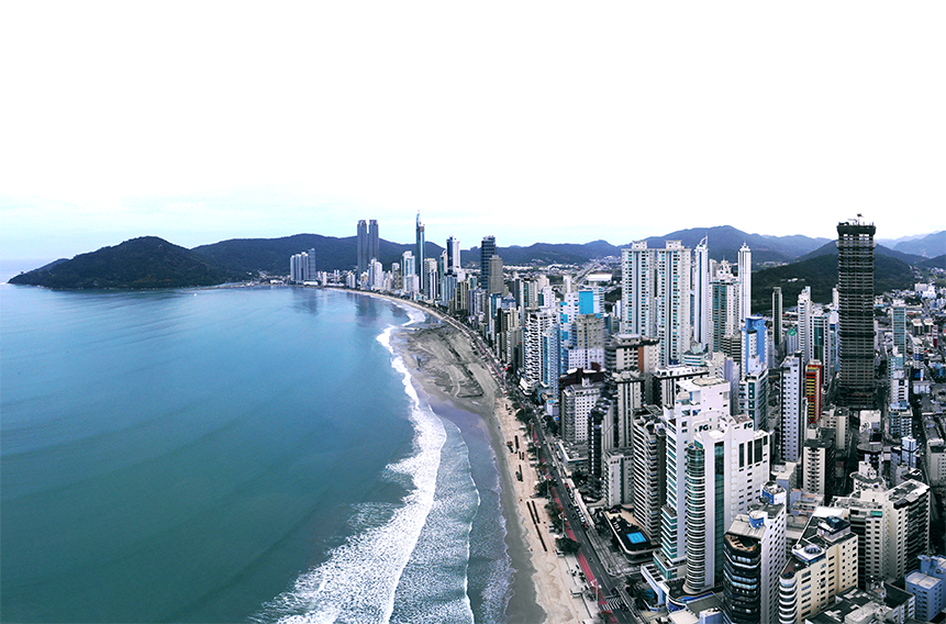Uma vista aérea de uma cidade com uma praia e um grande corpo de água.