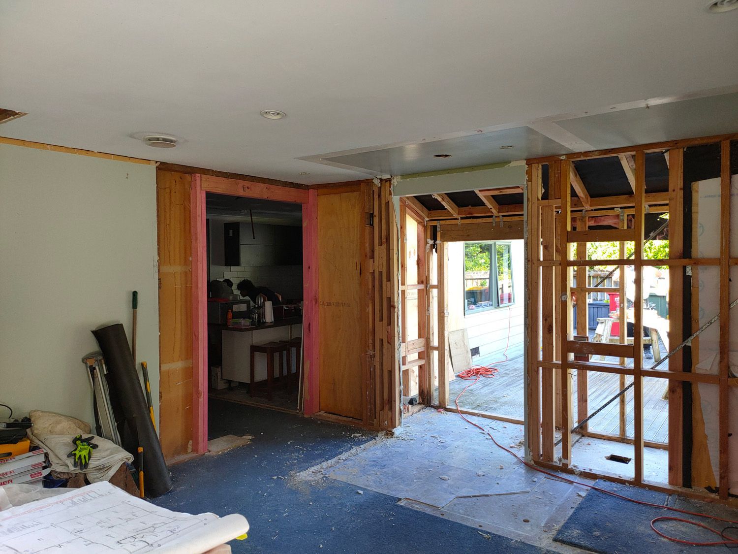 Interior room under construction, with exposed wooden framing and doorways.