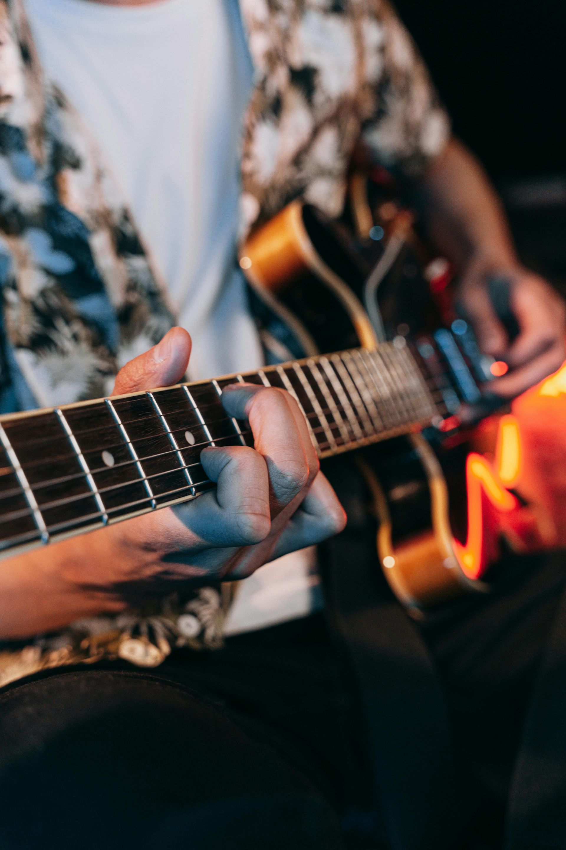 A man is playing an electric guitar in a dark room.