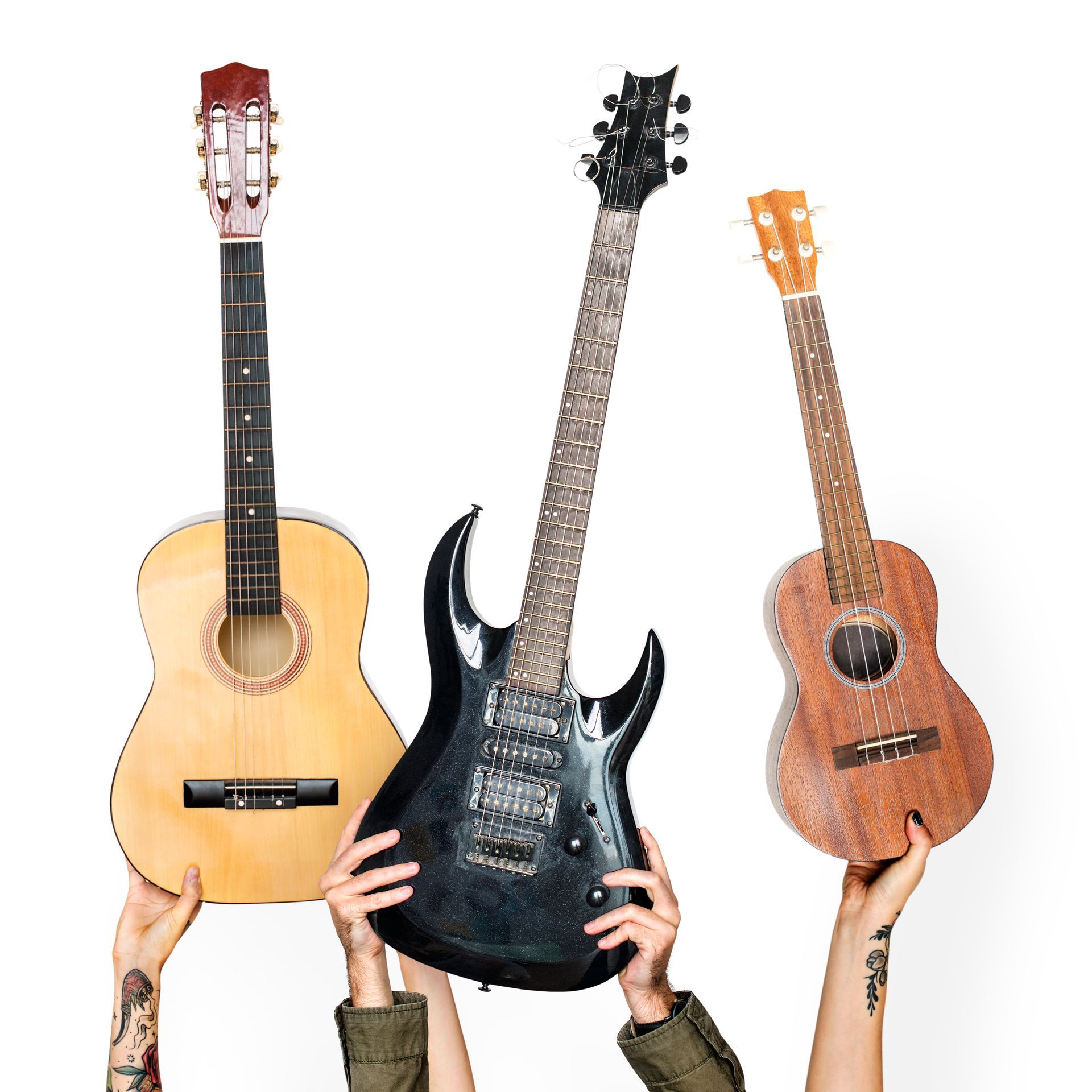 A group of people are holding up three guitars.