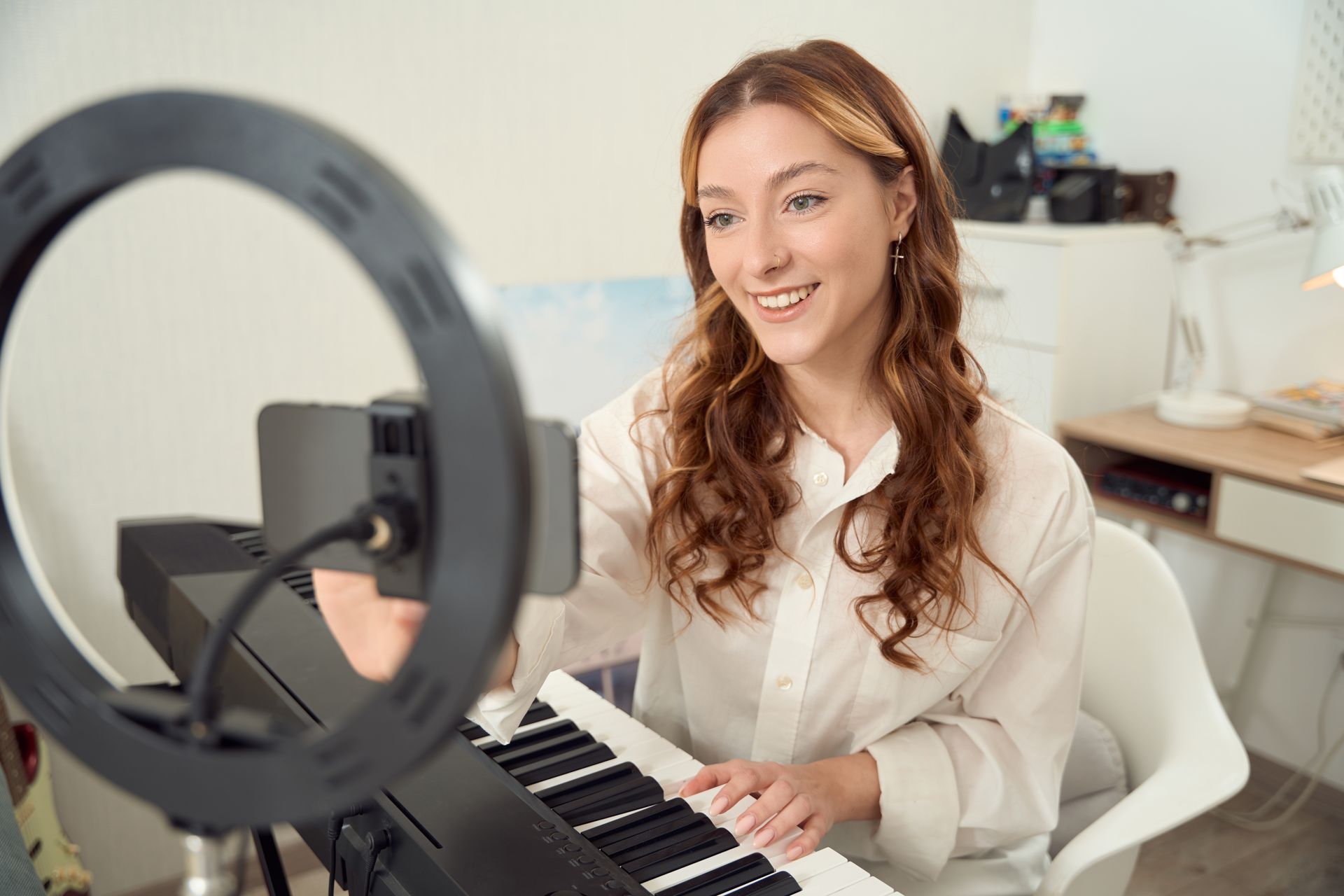 A woman is taking a selfie while playing a piano.