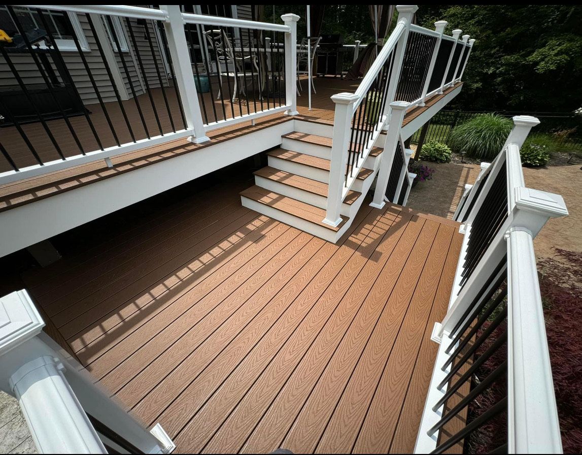 A wooden deck with stairs and a white railing