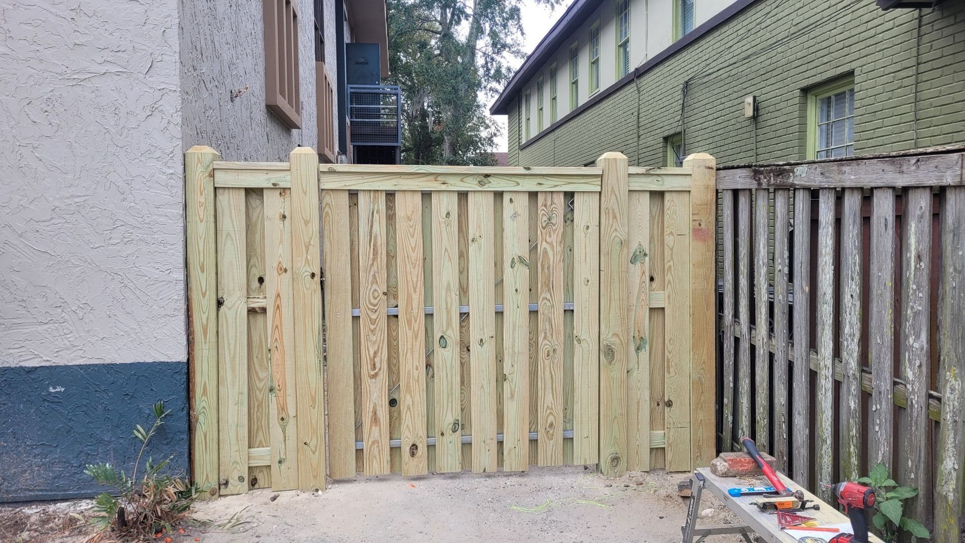 A wooden fence is being built in front of a building.