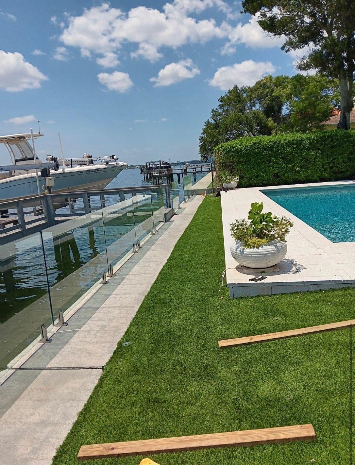 A boat is docked in a marina next to a swimming pool.