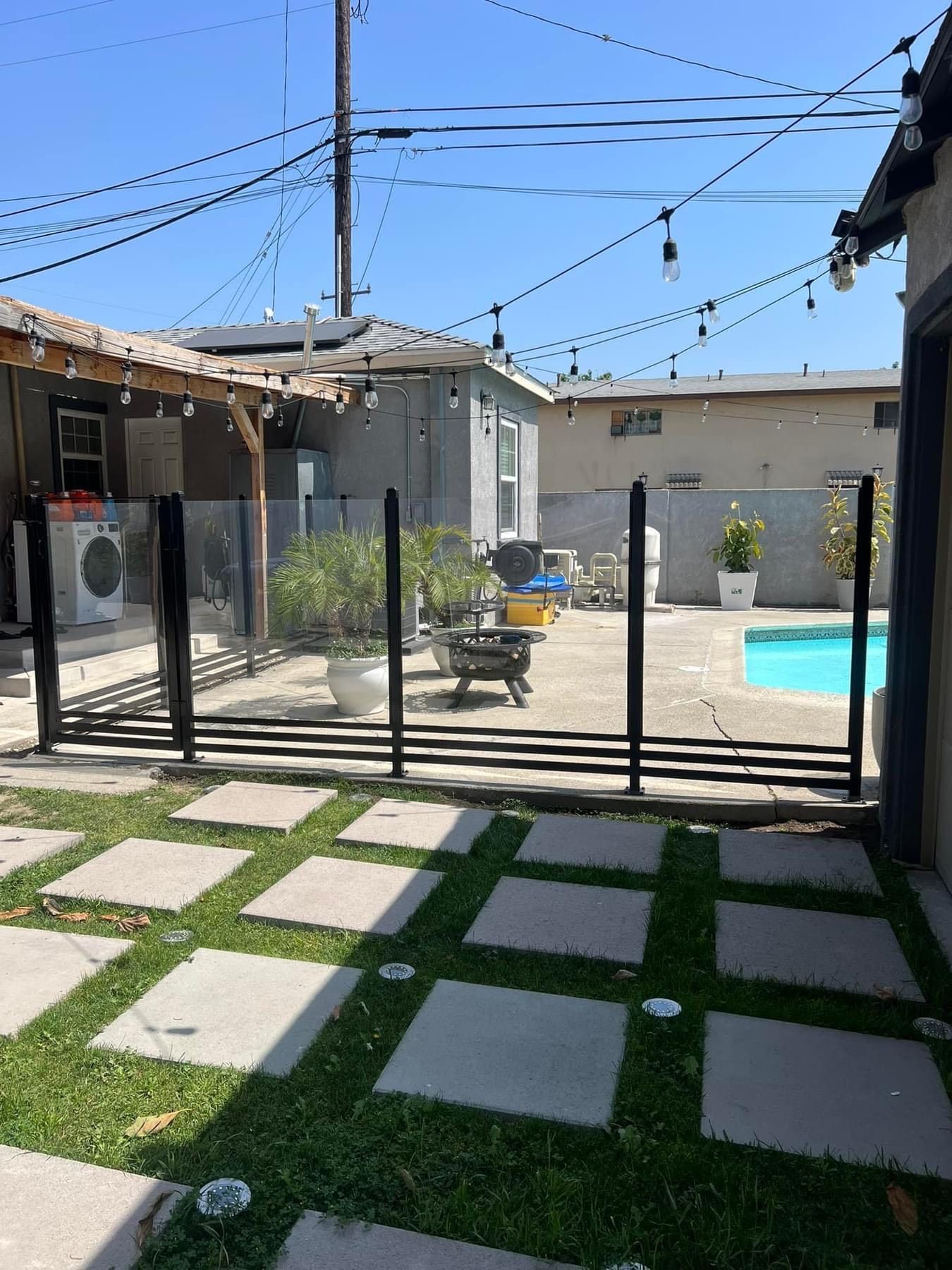 A backyard with a fence and a swimming pool.