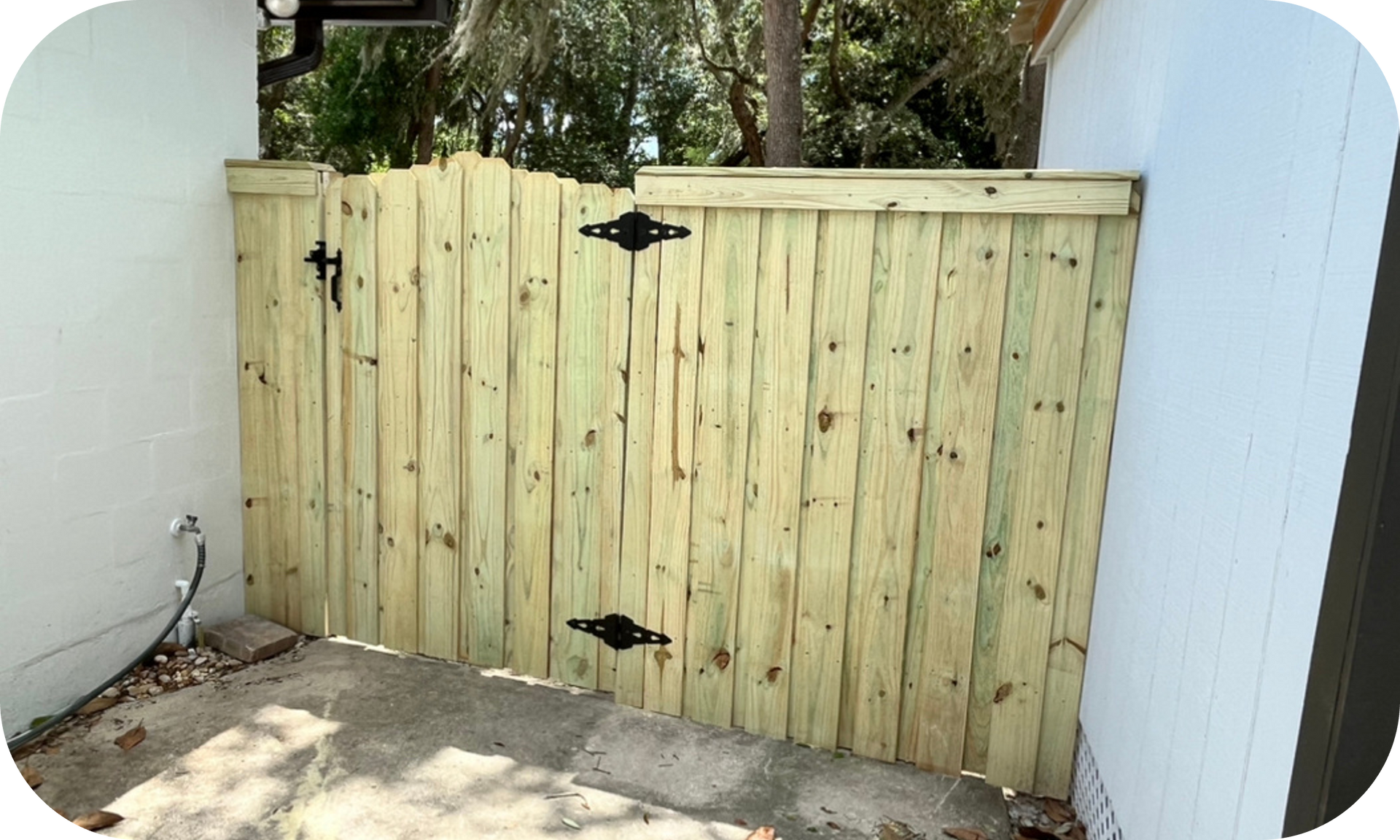 A wooden fence is sitting next to a white building.