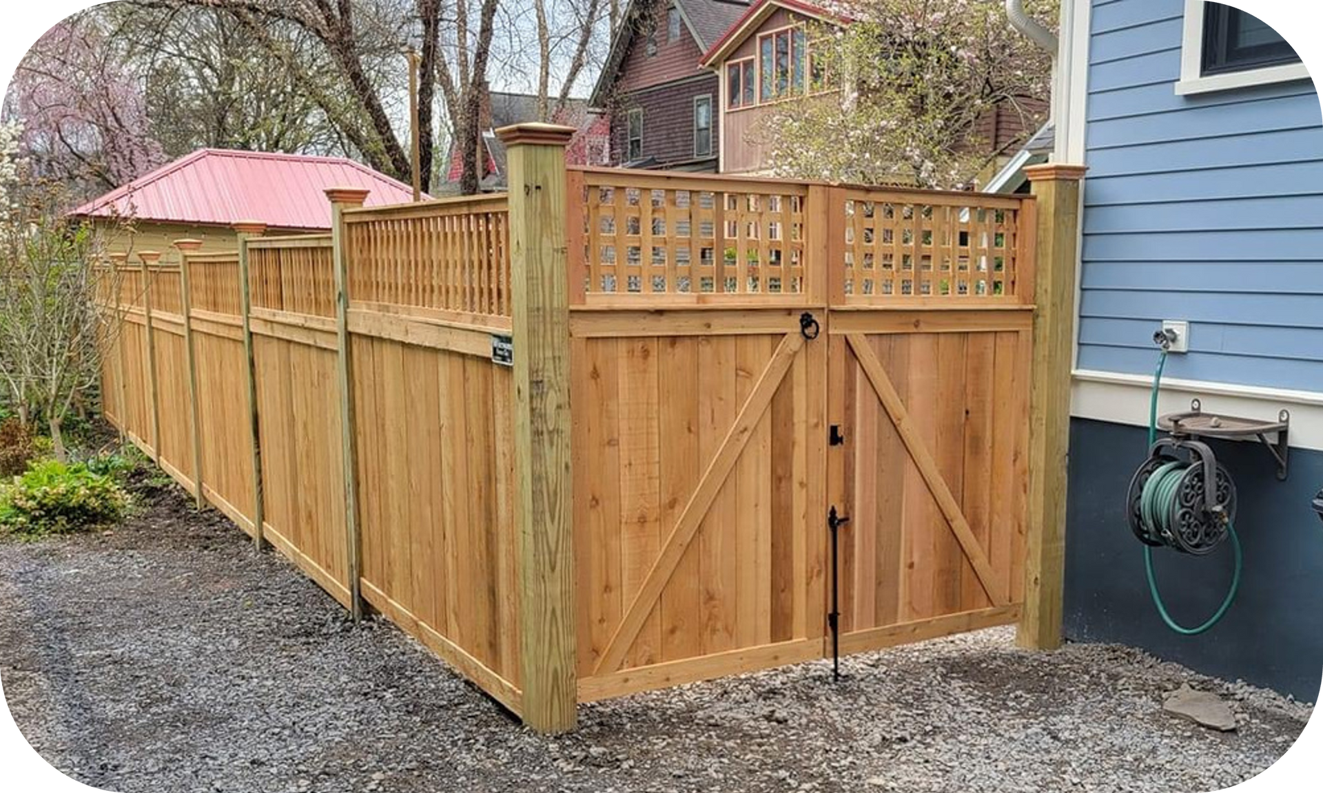 A wooden fence with a gate in front of a house.