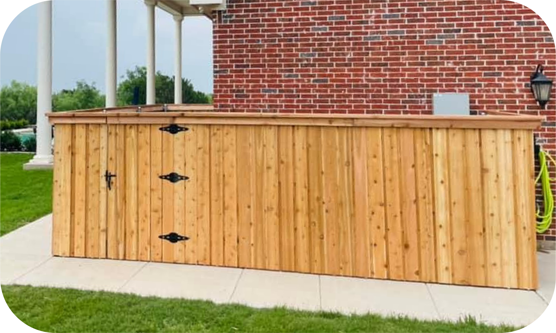 A wooden fence is in front of a brick building