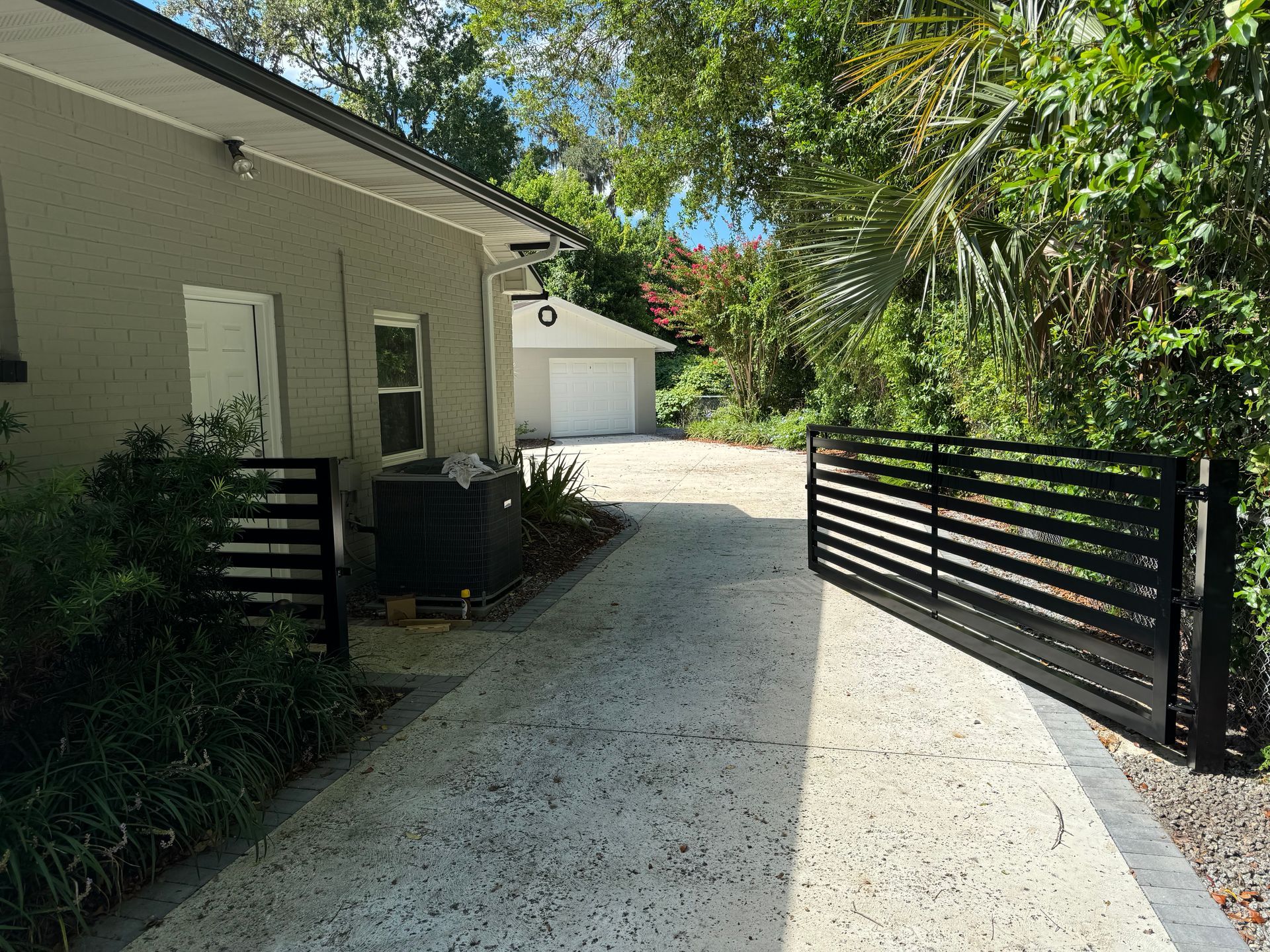 A driveway leading to a house with a sliding gate