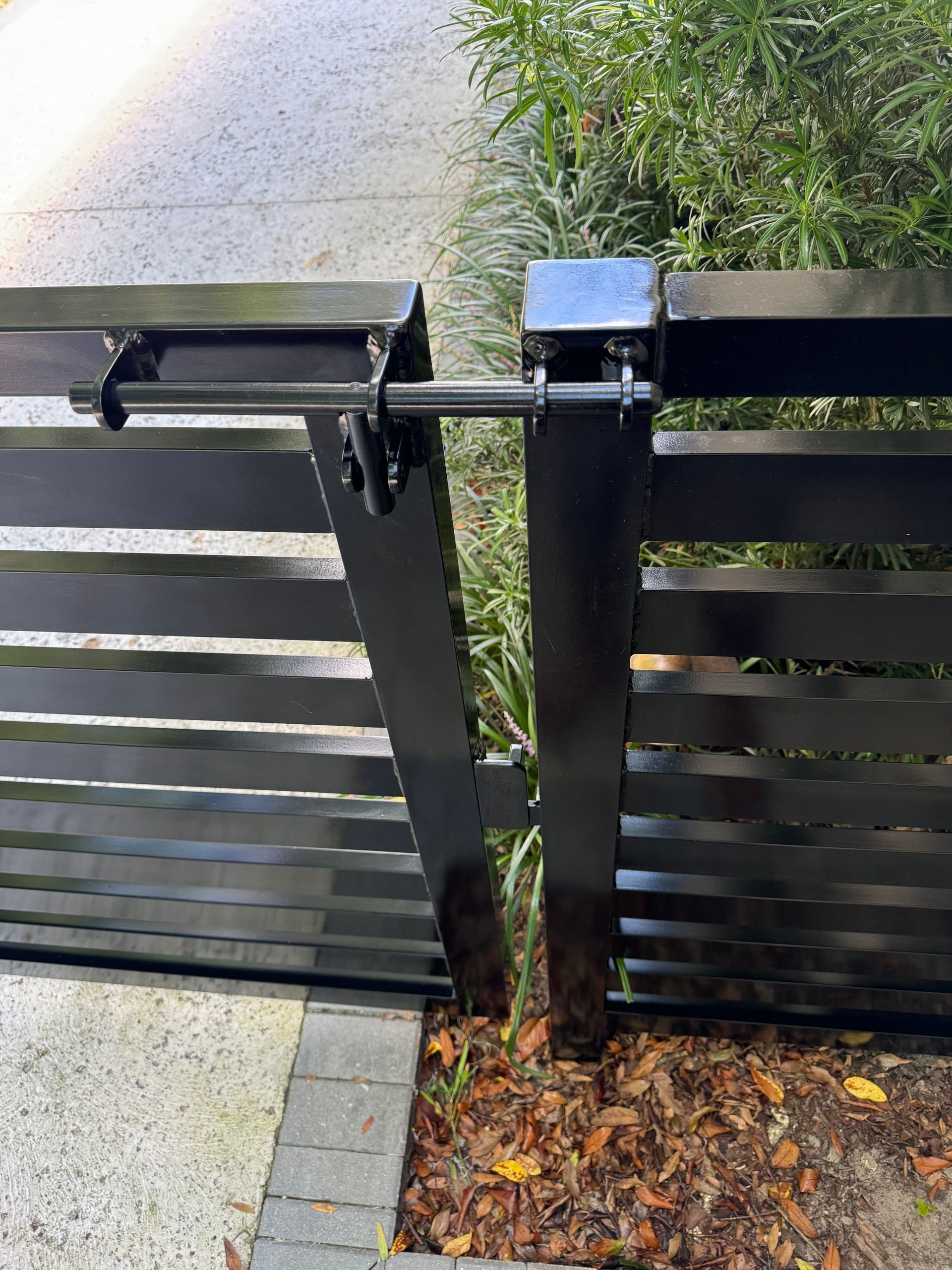 A black fence with a gate that is open and locked.