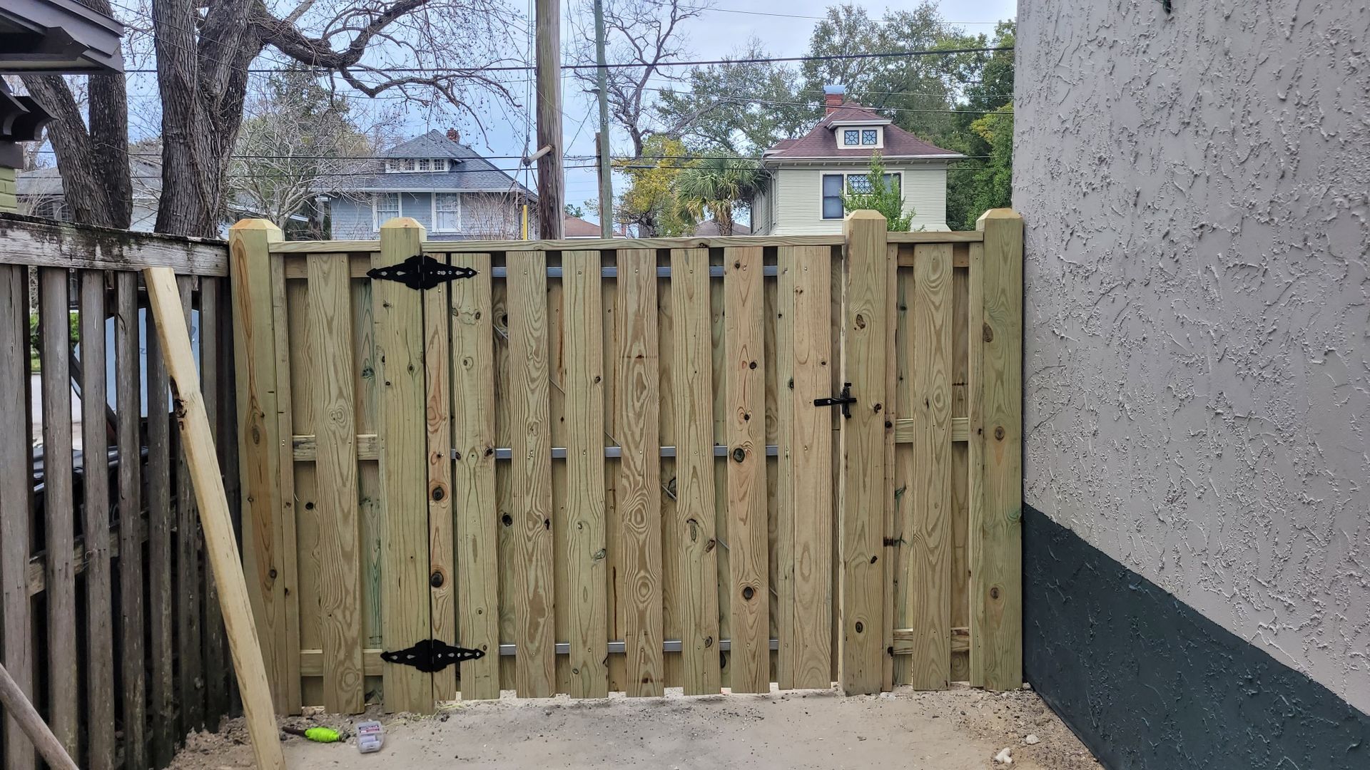 A wooden fence with a gate is being built in front of a building.
