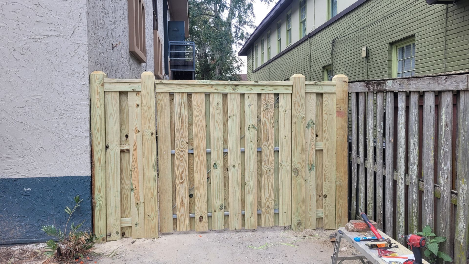 A wooden fence is being built in front of a building.