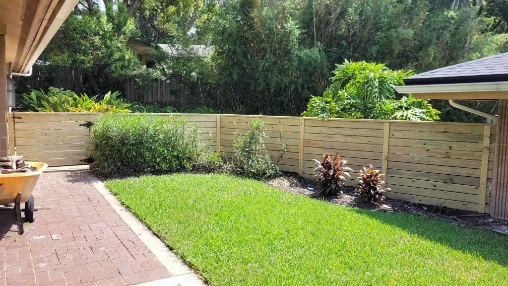 There is a wooden fence in the backyard of a house.