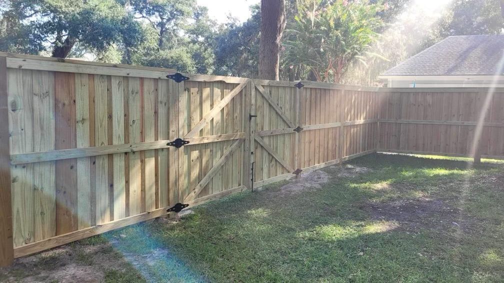 A wooden fence with a gate in the backyard of a house.