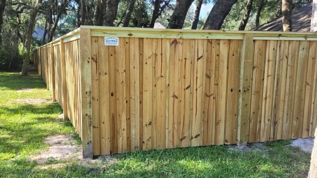 A wooden fence is sitting in the middle of a lush green field.