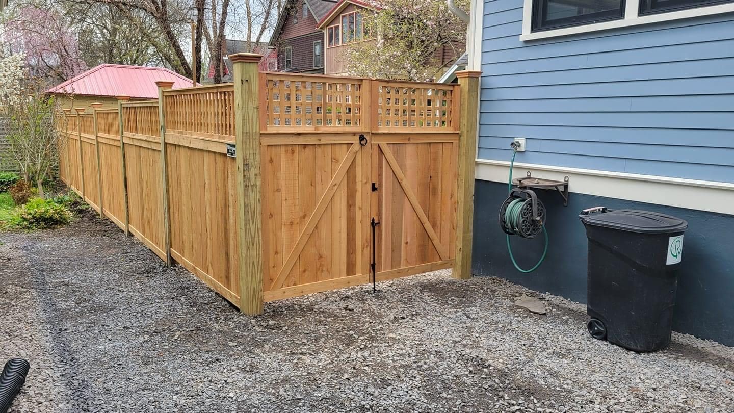A wooden fence with a gate in front of a house.