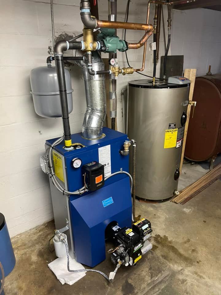 A blue boiler is sitting in a basement next to a water heater.