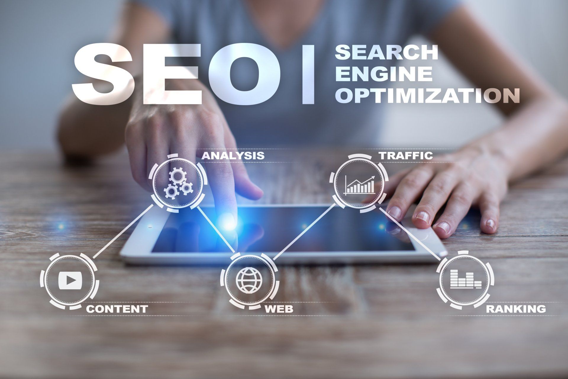 Person interacting with tablet, SEO graphic overlay: content, web, ranking, analysis, and traffic.