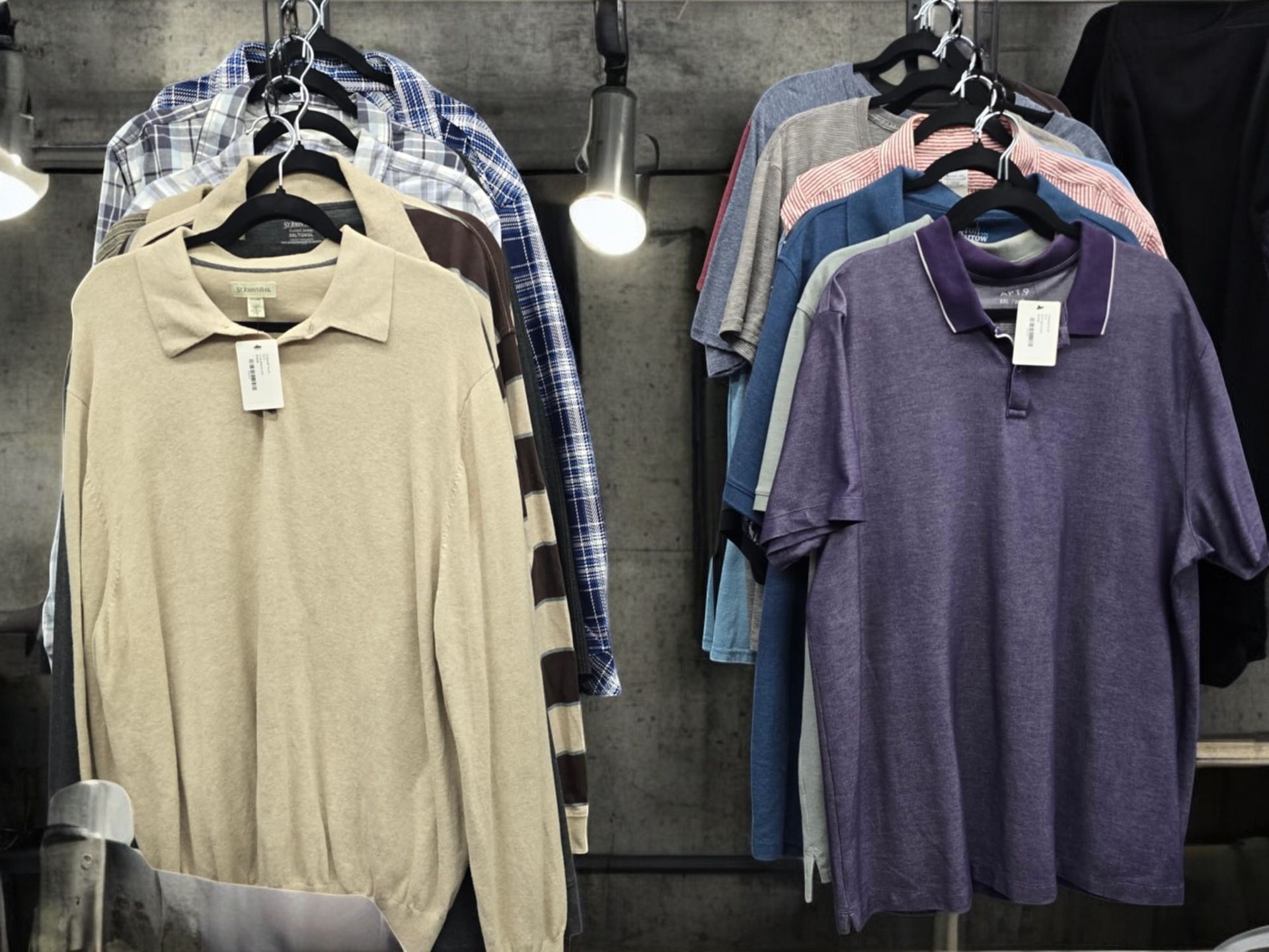 A bunch of shirts are hanging on a rack in a store