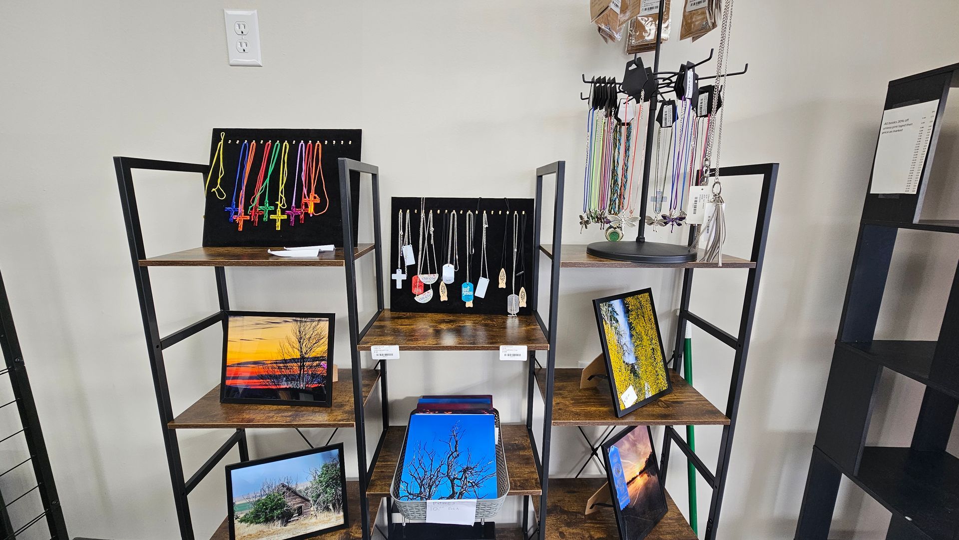 A woman wearing a black sweatshirt is sitting on a wooden bench.