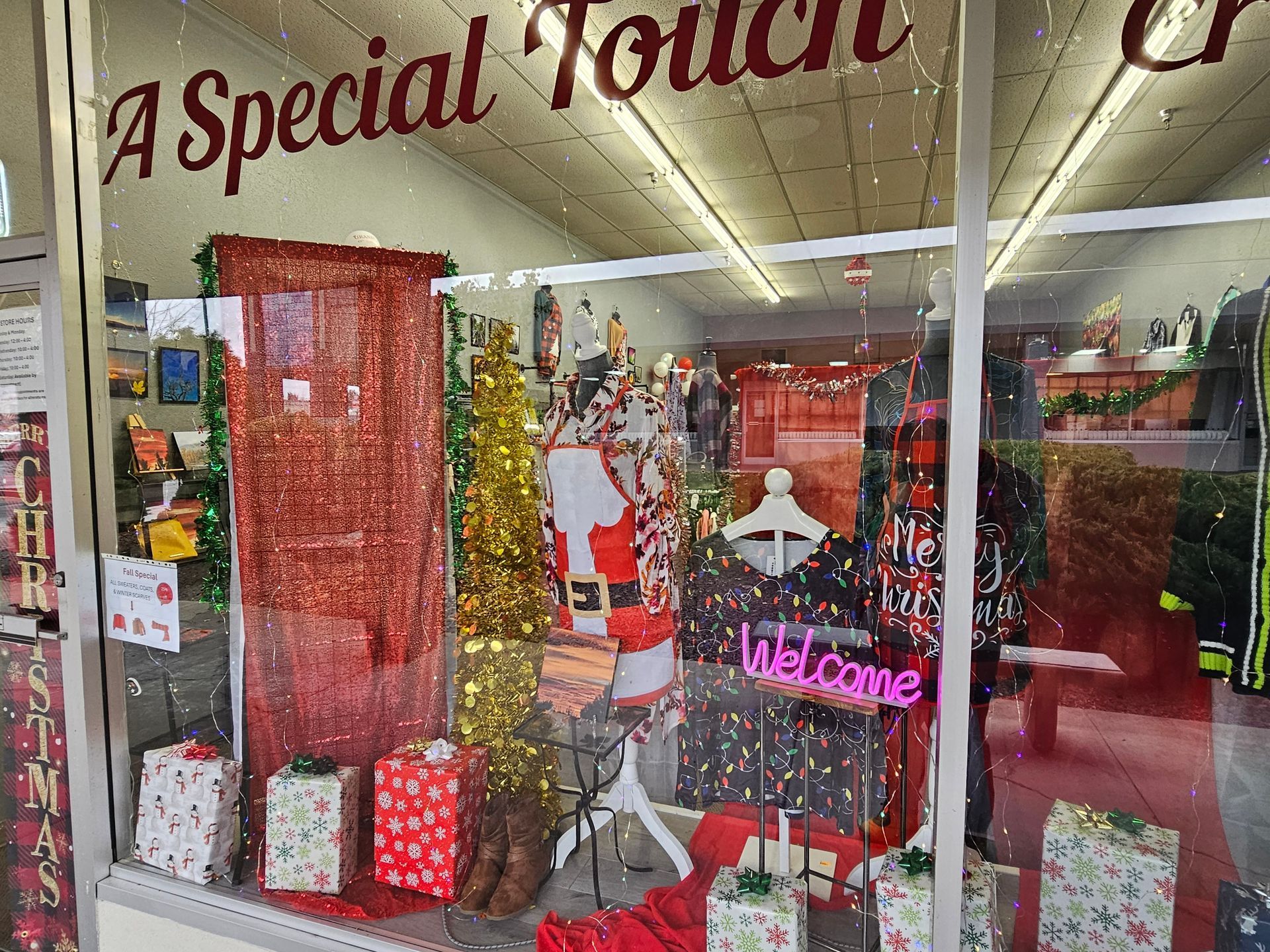 A store window with christmas decorations and a neon sign that says welcome