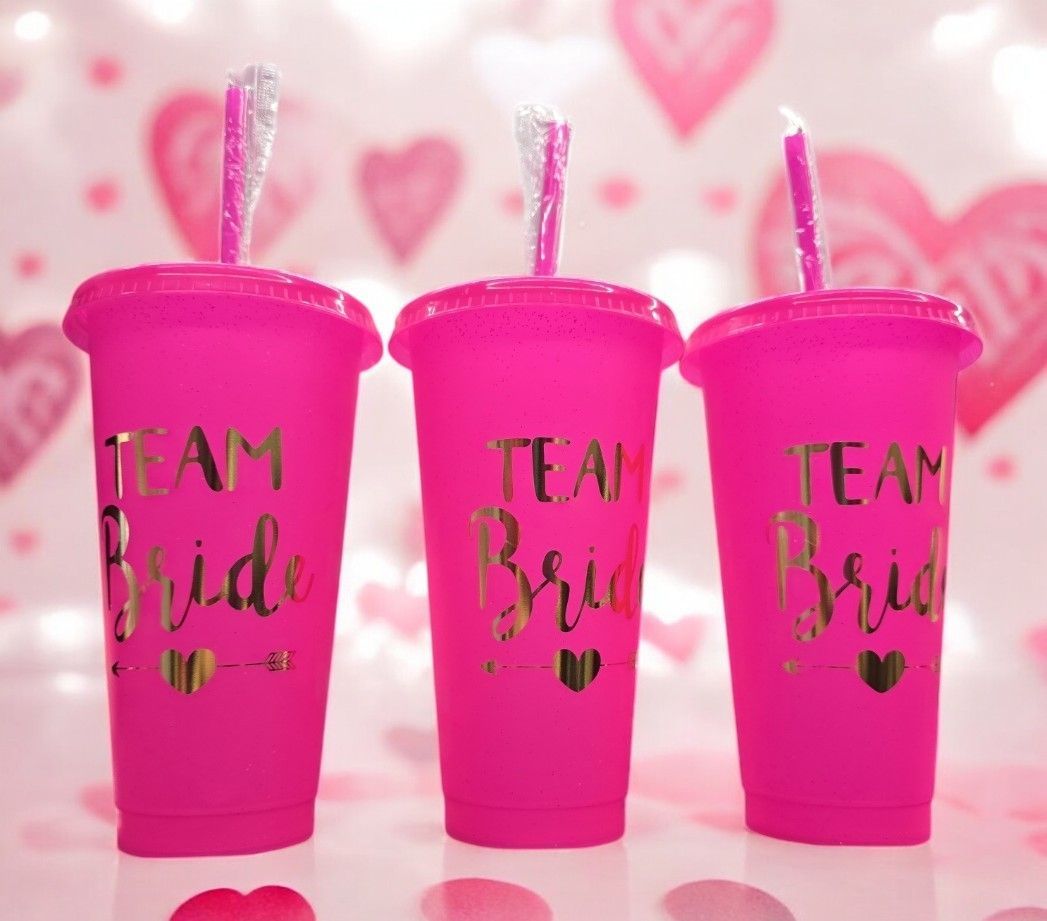 Three pink cups that say team bride on them
