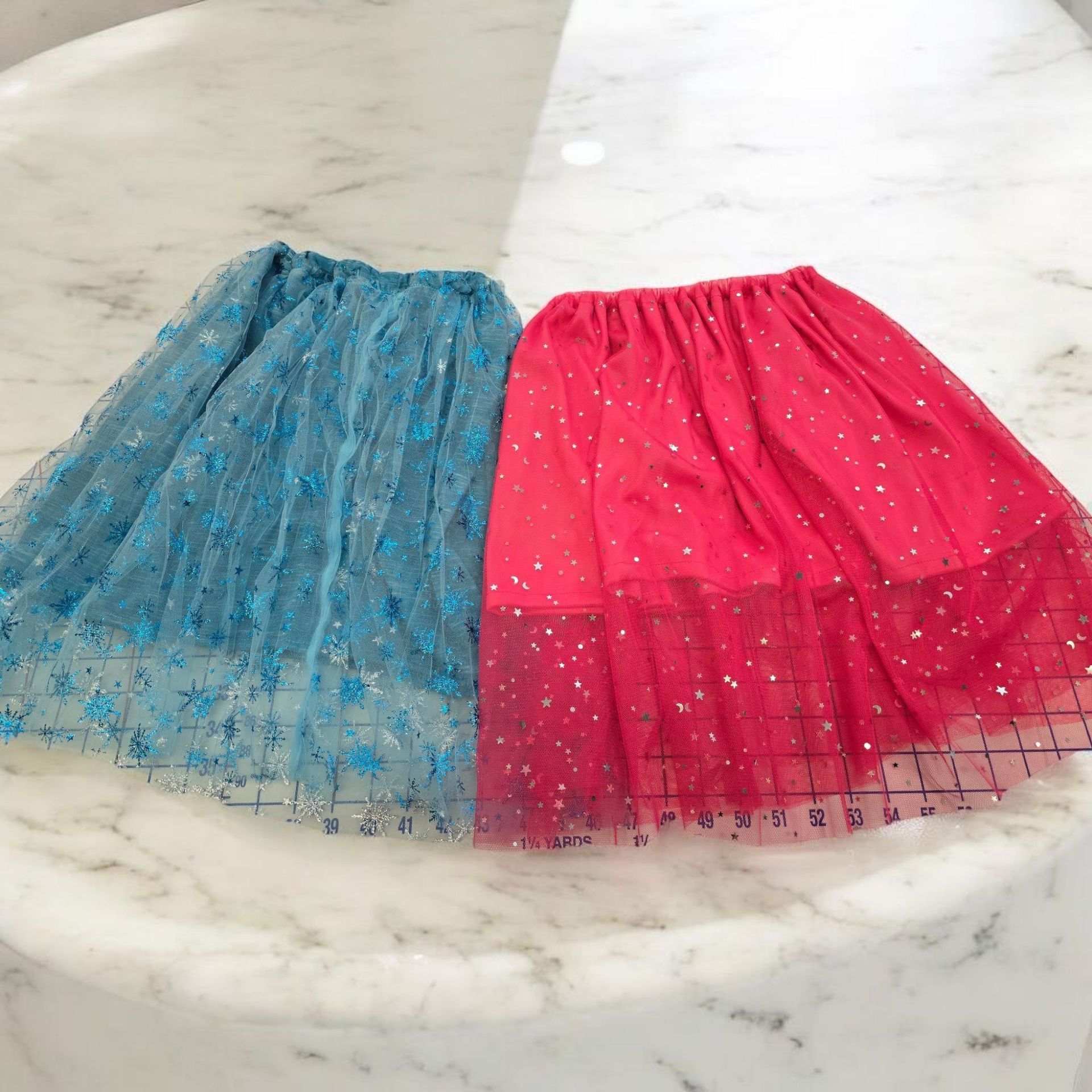 A blue and a red skirt are on a table