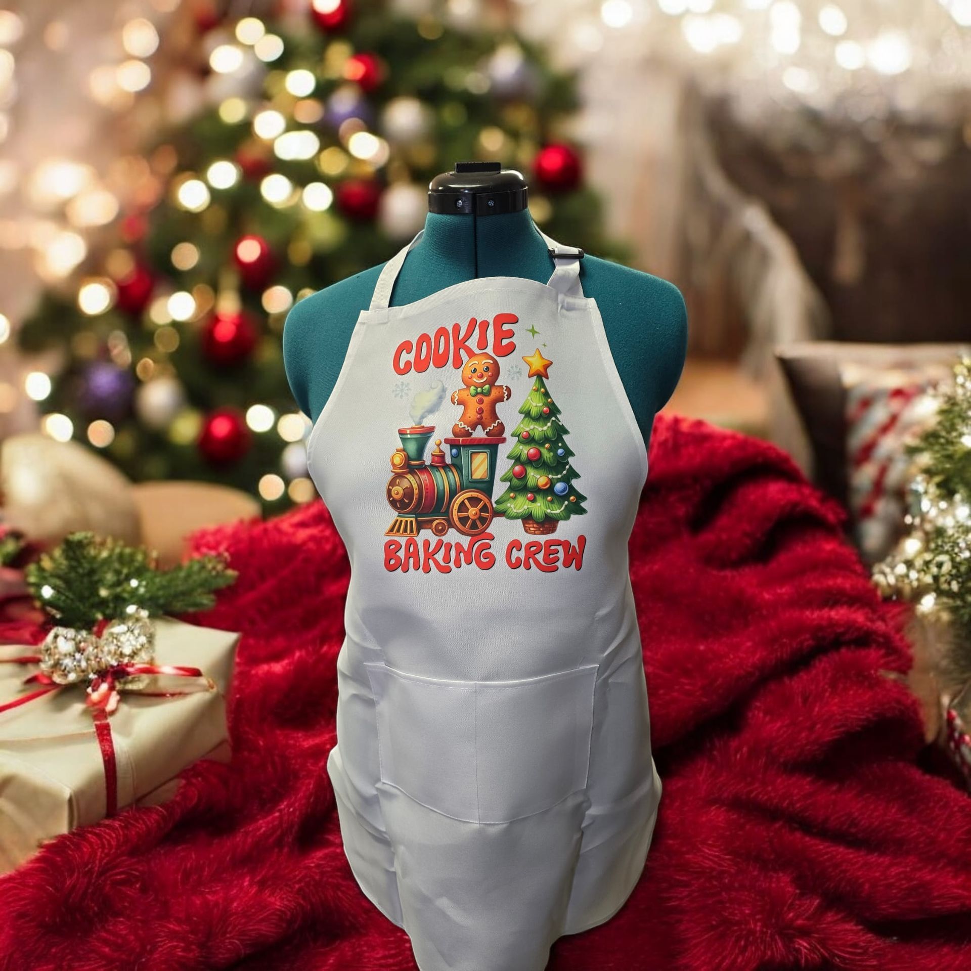 A cookie baking crew apron is on a mannequin in front of a christmas tree