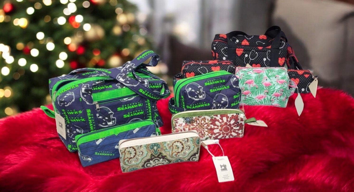 A group of pencil cases are sitting on a red blanket in front of a christmas tree.