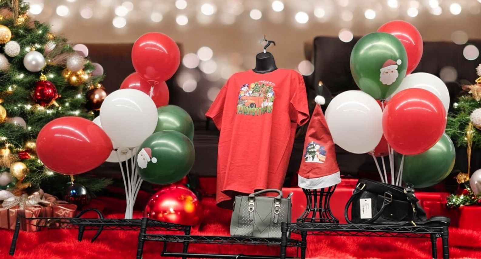 A display of christmas clothes and balloons with a christmas tree in the background.