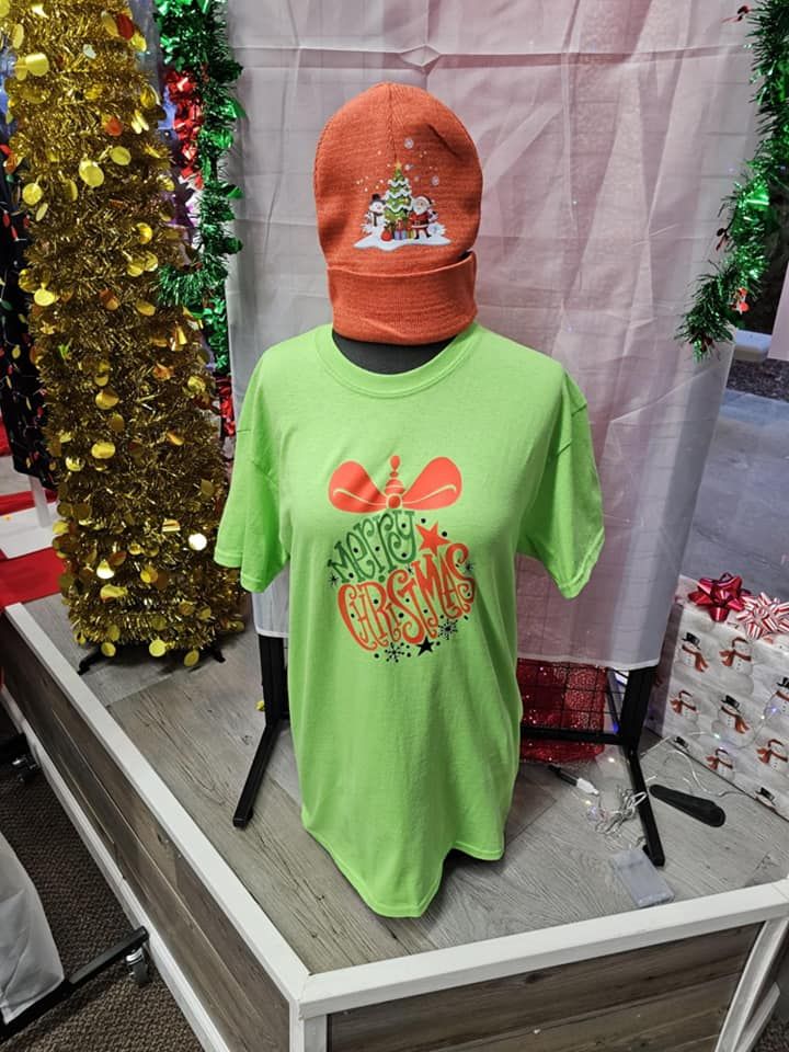 A green t-shirt and an orange hat are on a mannequin.
