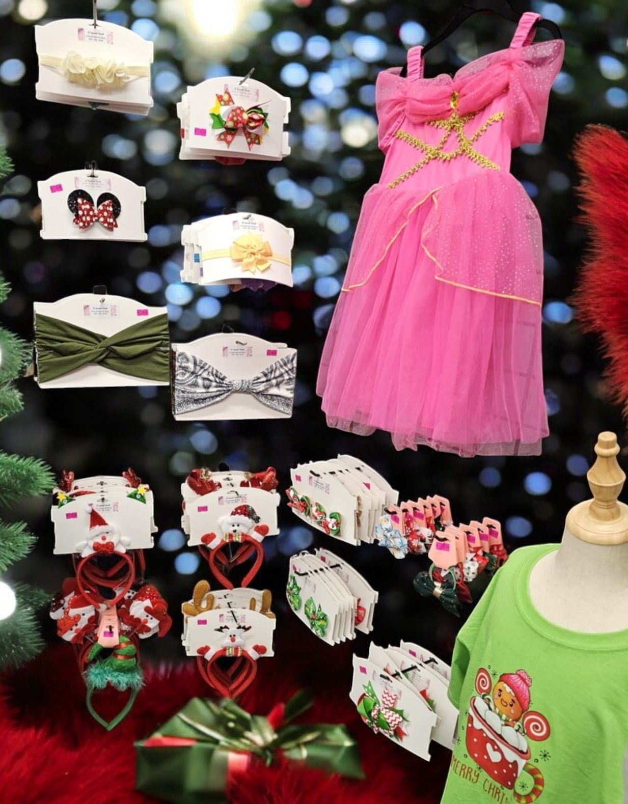 A pink dress and a green shirt are on display in front of a christmas tree