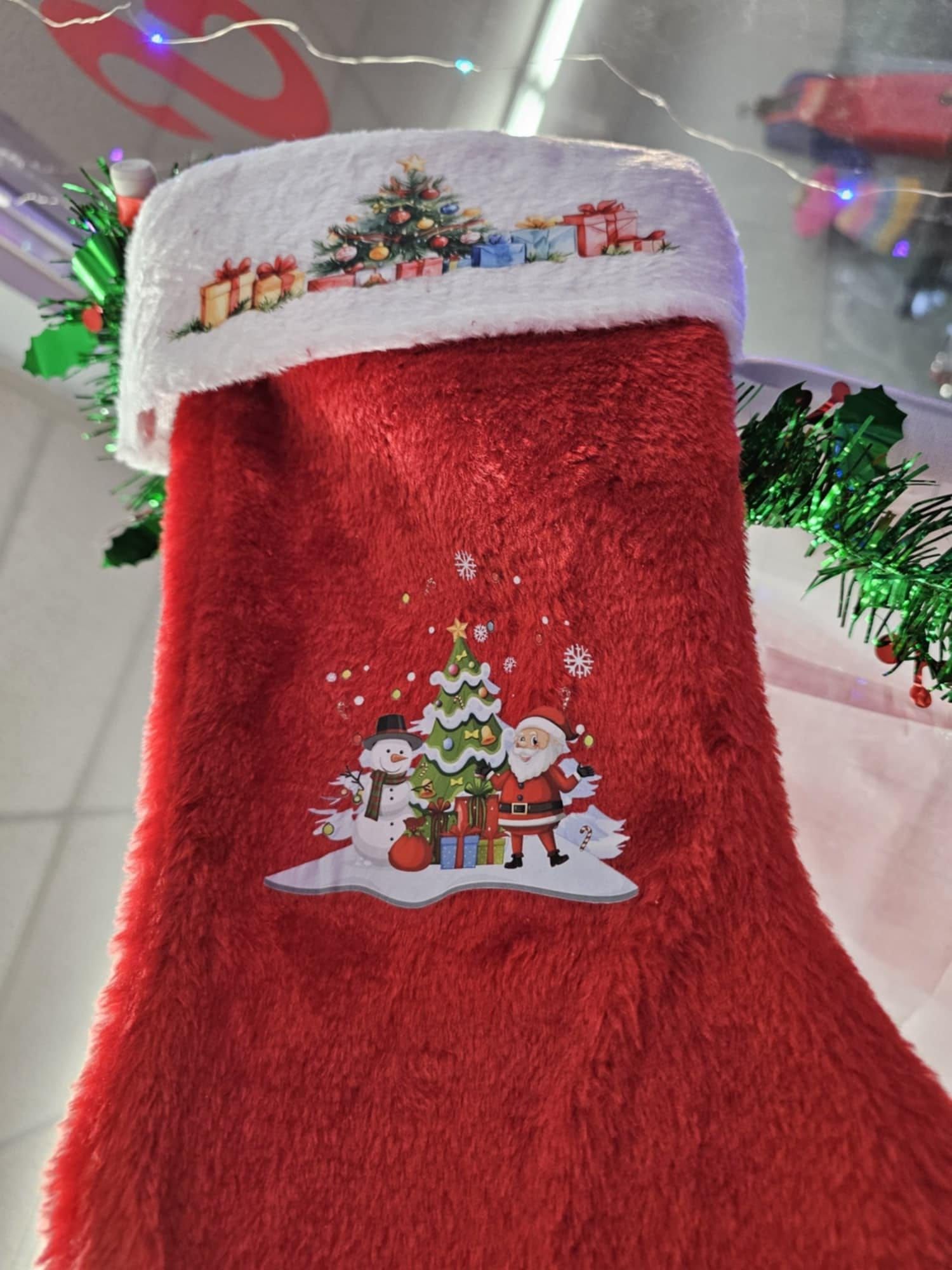 A red christmas stocking with santa claus and a christmas tree on it