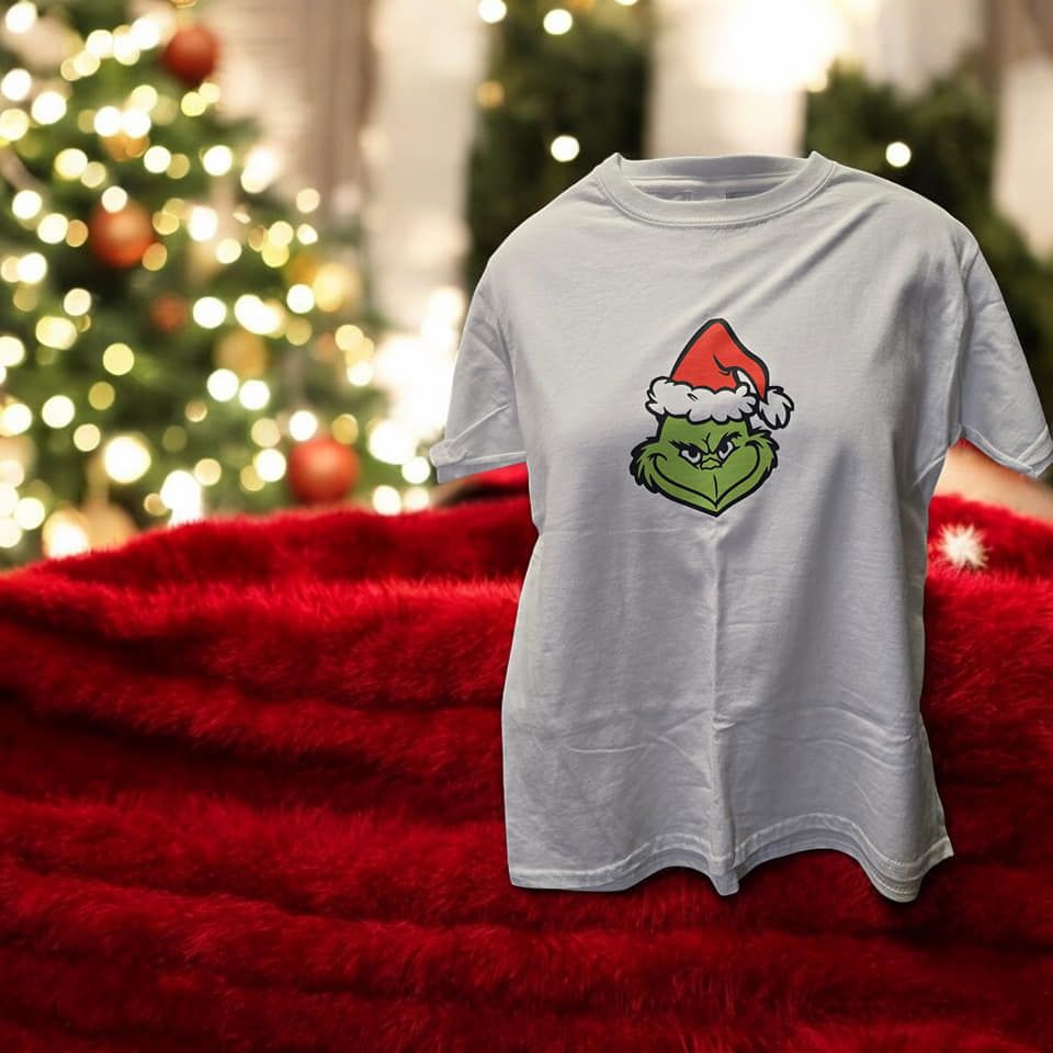 A white t-shirt with a grinch face on it