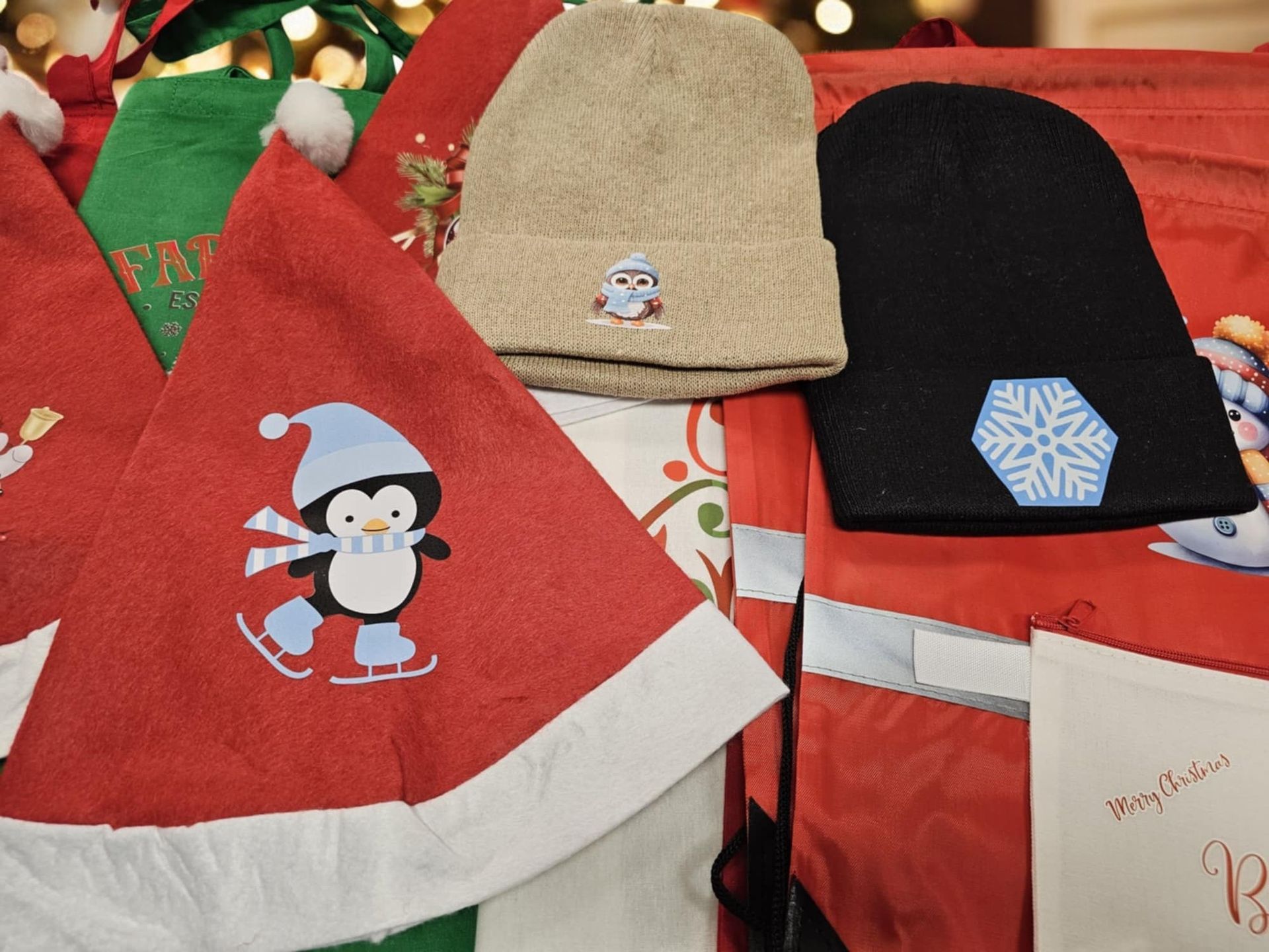 A pile of christmas hats including one with a penguin on it
