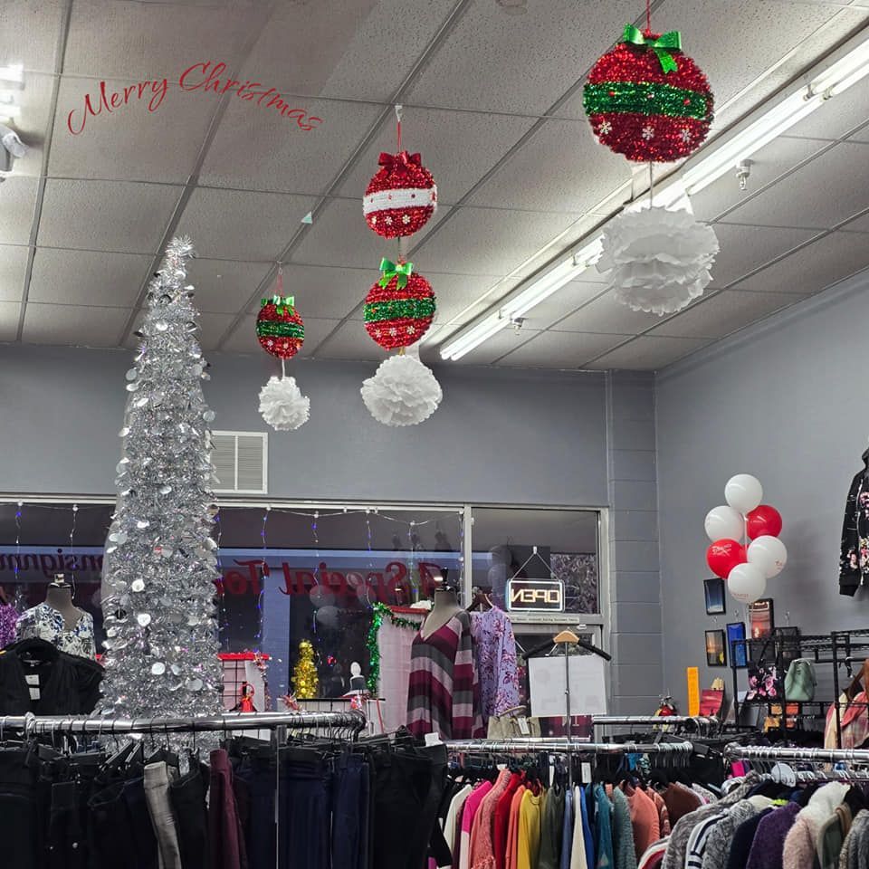 A merry christmas sign hangs from the ceiling of a store