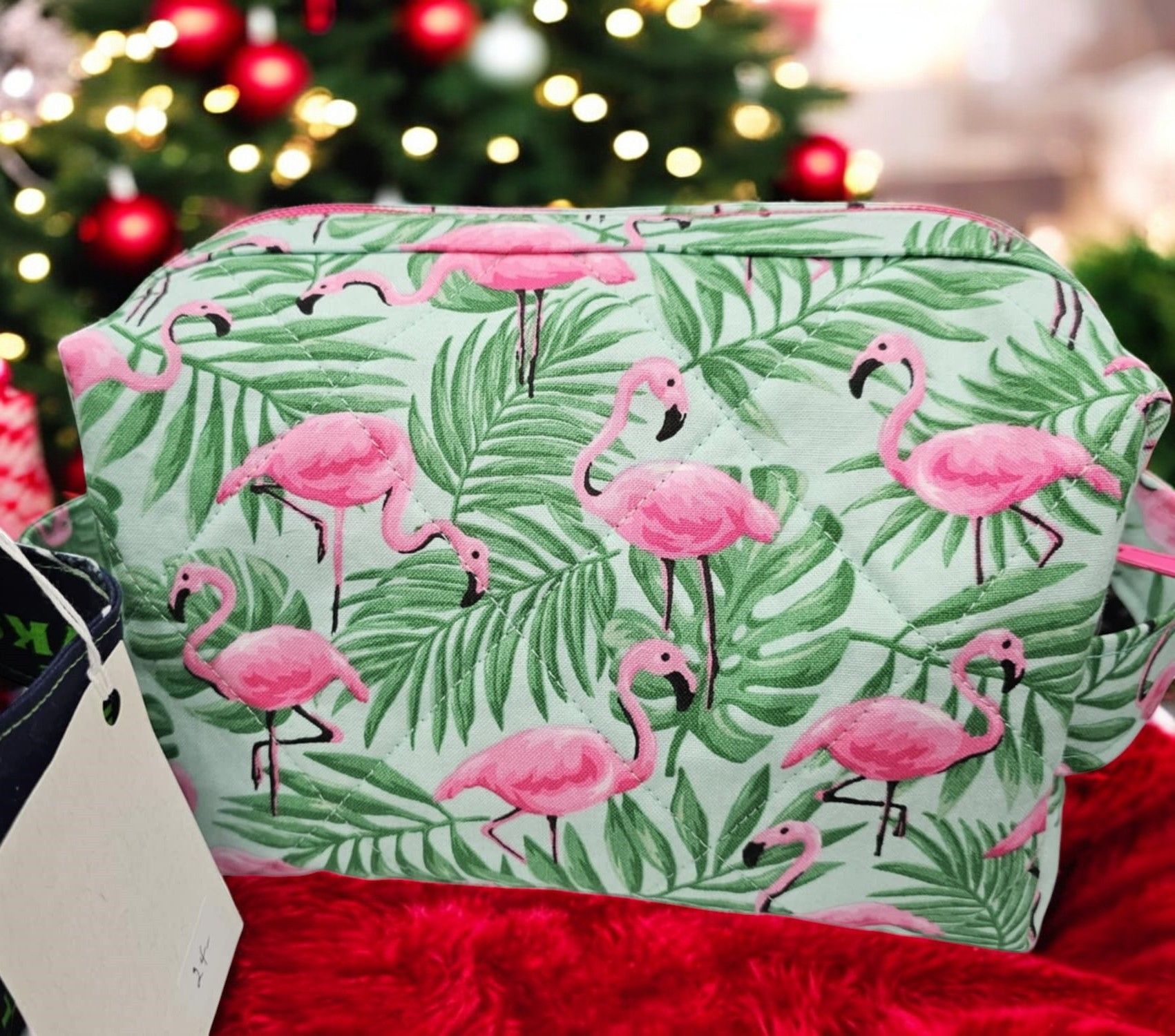 A cosmetic bag with flamingos and palm leaves on it