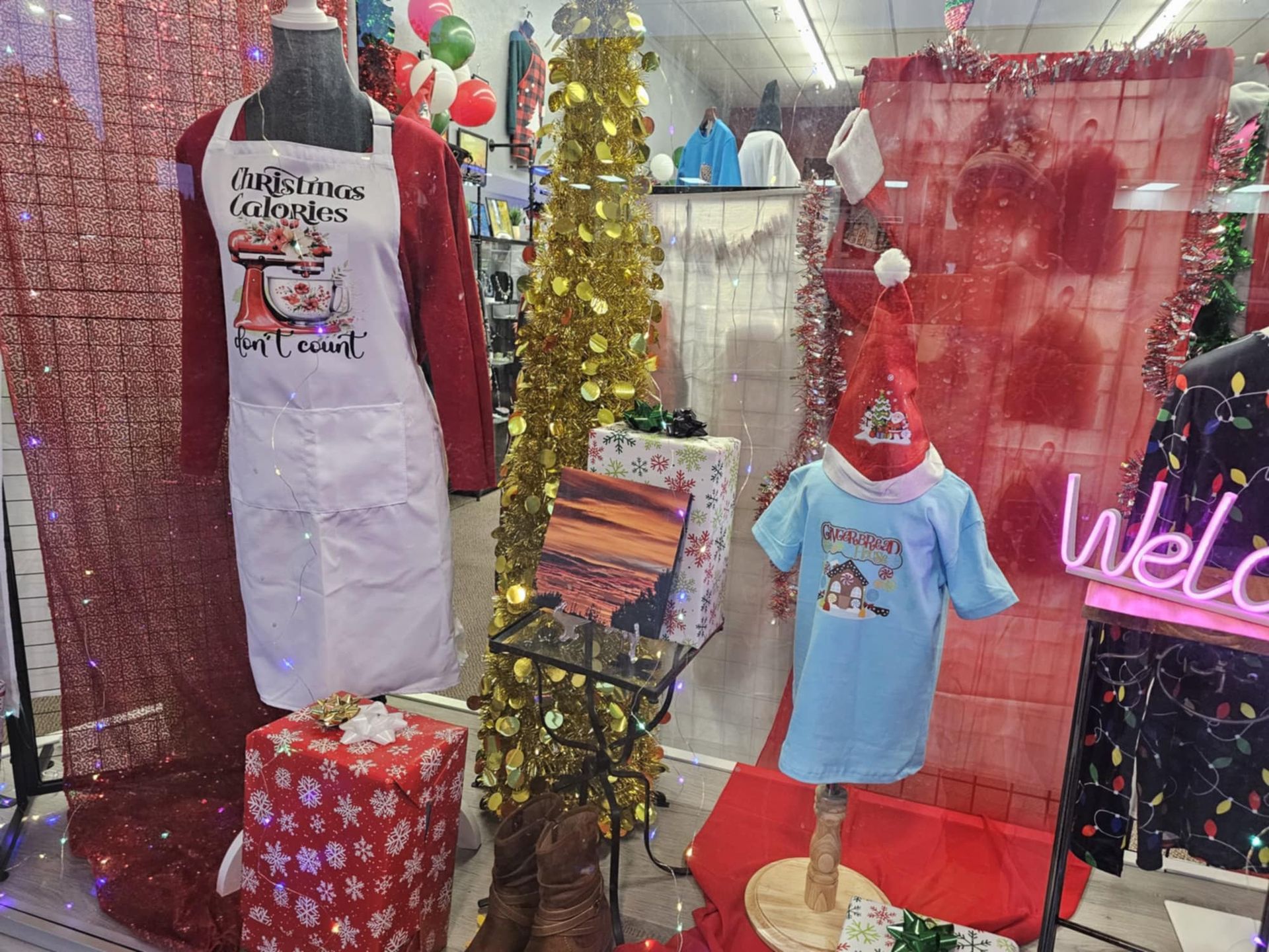 A christmas display in a store window with a mannequin wearing an apron.