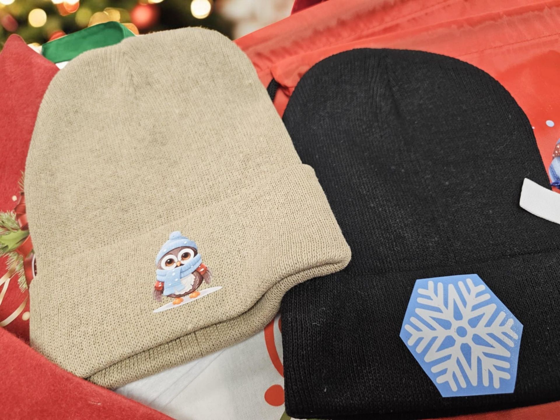 Two beanies with penguins and snowflakes on them