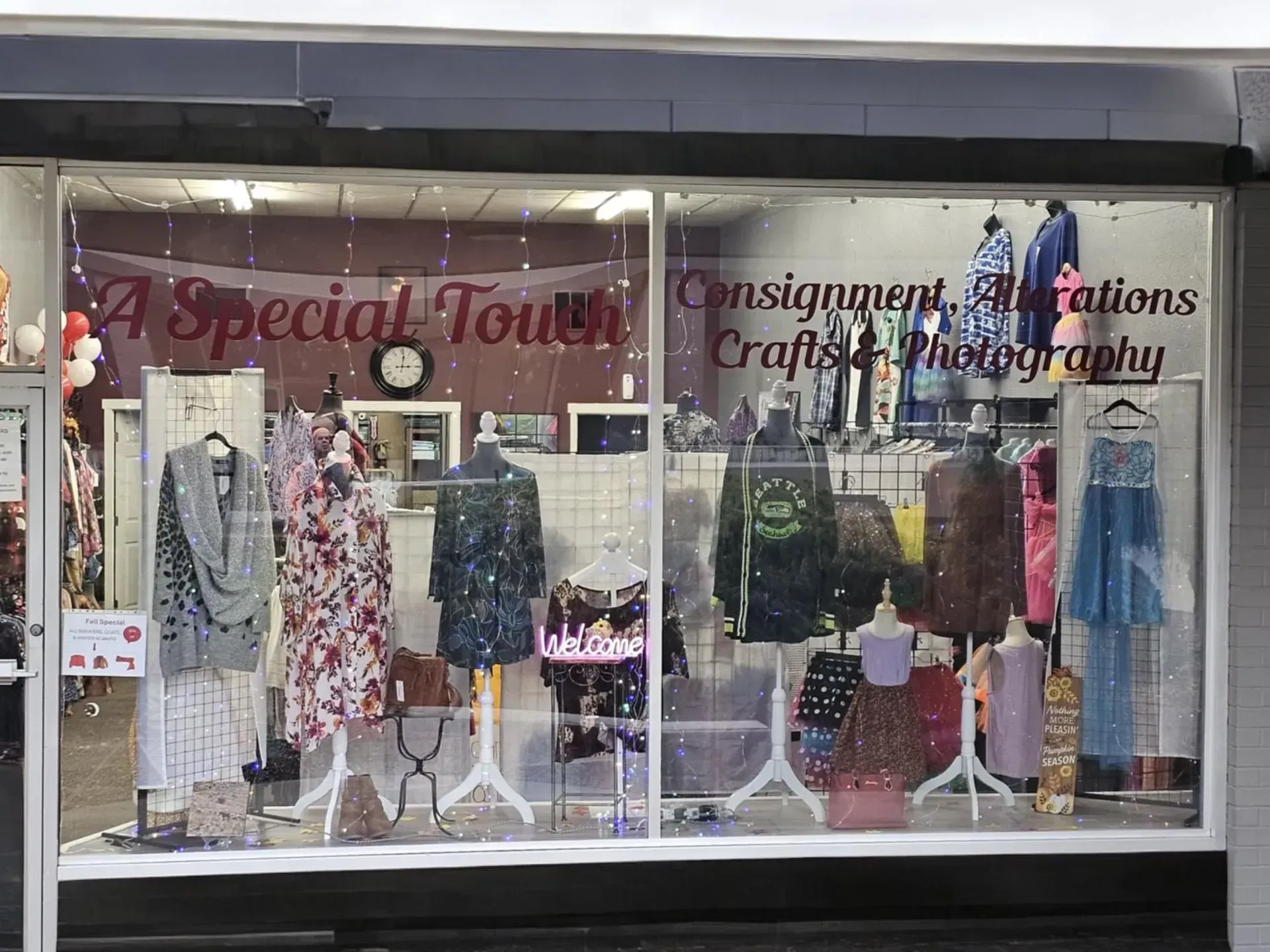 A store front with a window display of clothes and mannequins.