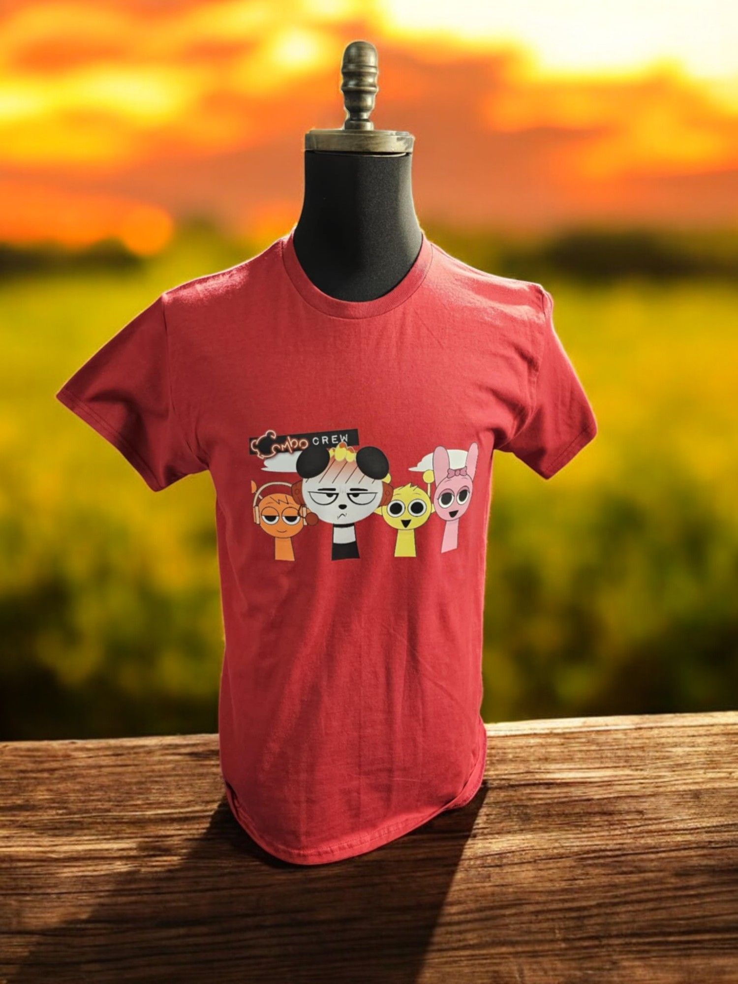 A red t-shirt is sitting on a wooden table.