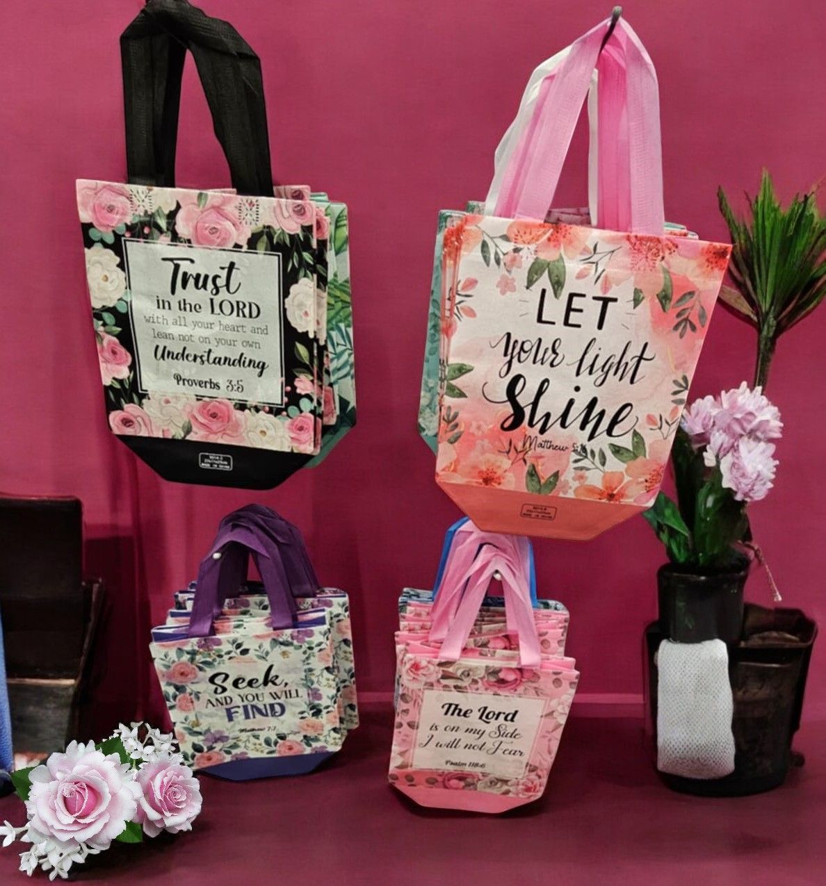 A pink tote bag that says let your light shine