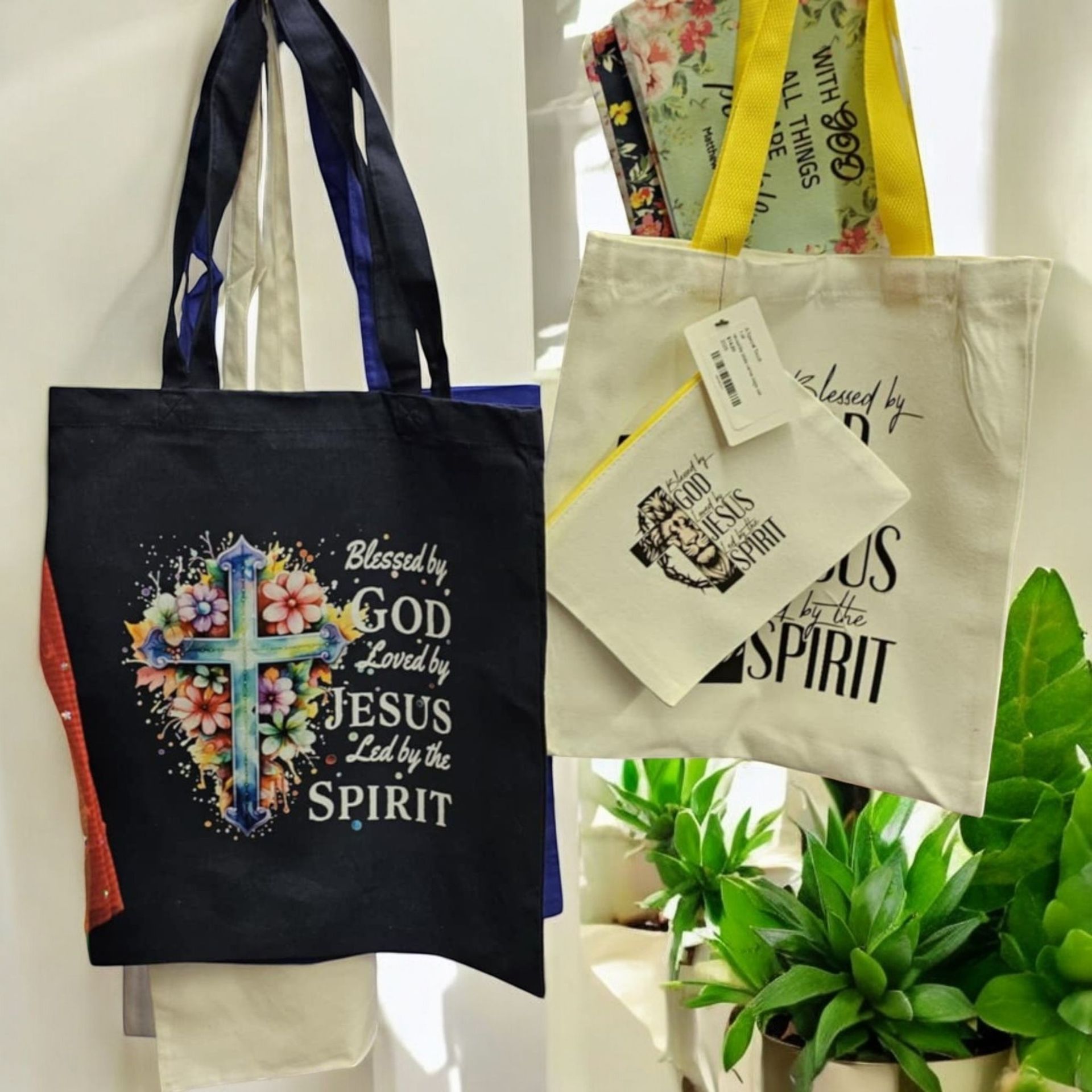 A tote bag that says blessed by god loved by jesus and spirit