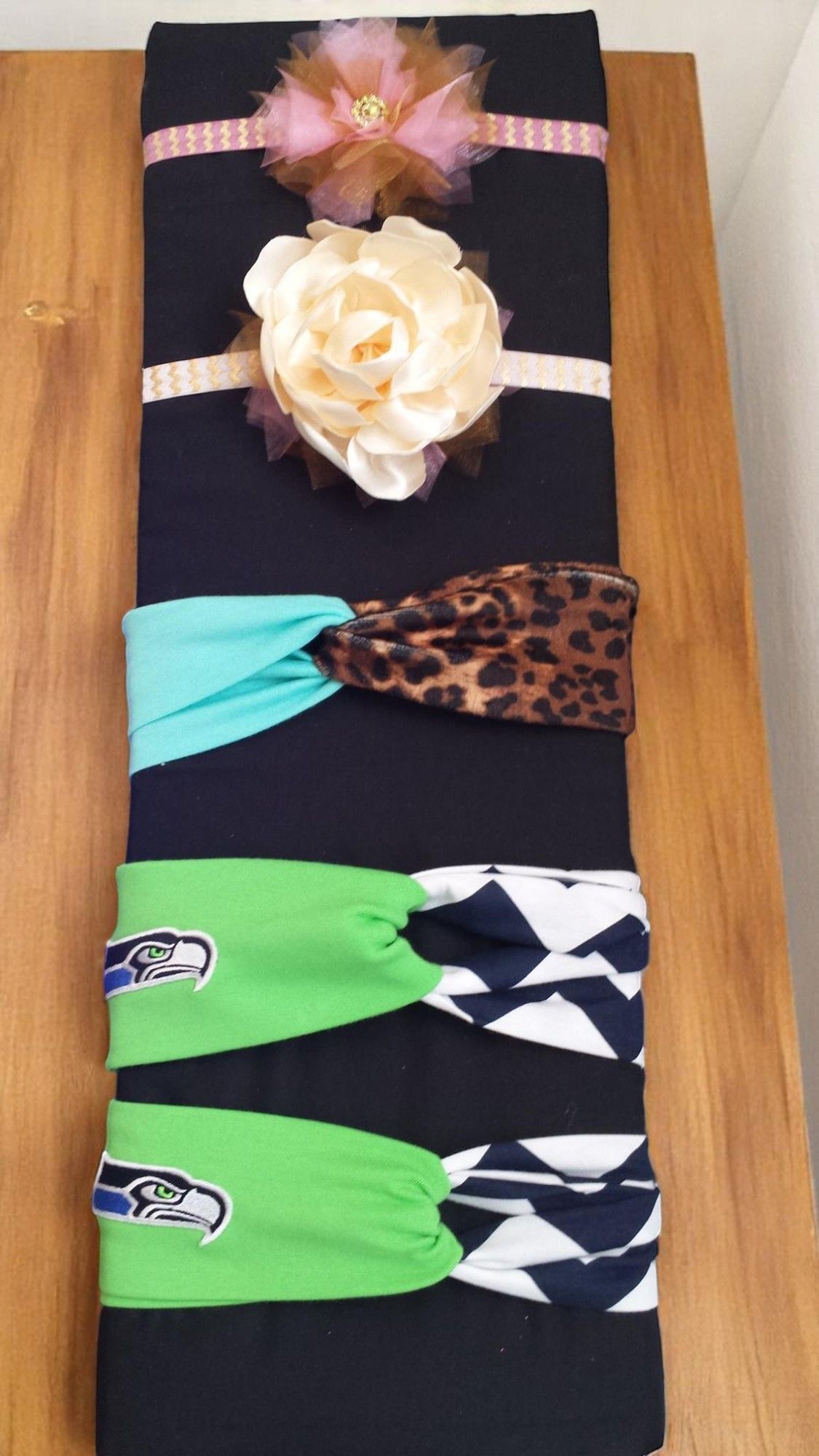 A bunch of headbands are stacked on top of each other on a wooden table.